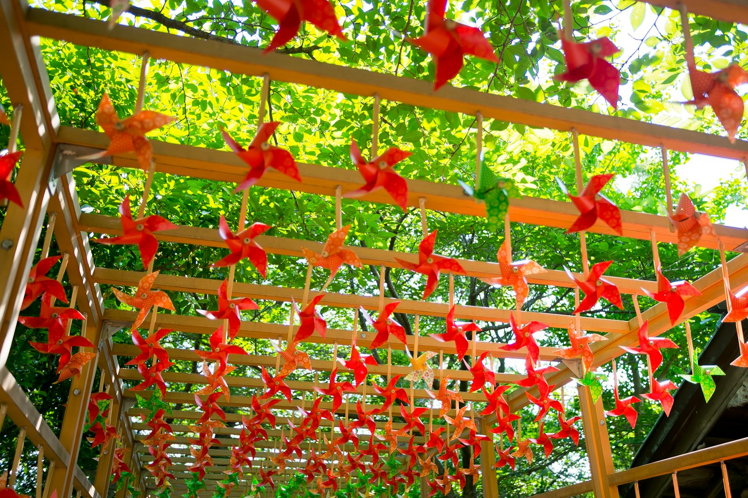 Un arco de madera adornado con molinetes rojos y naranjas