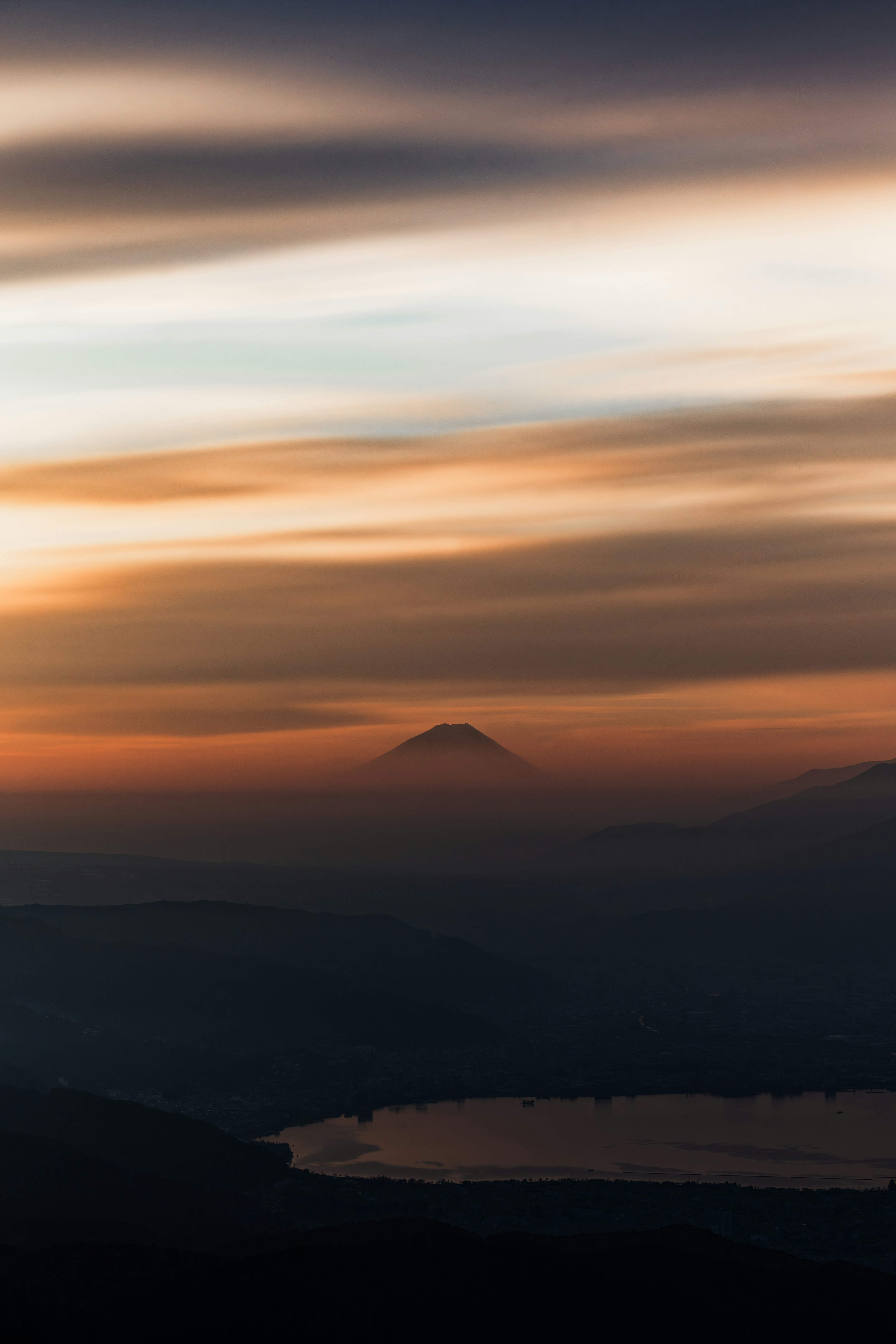 夕暮れの海と山並み、遠景の島影が浮かぶ景色