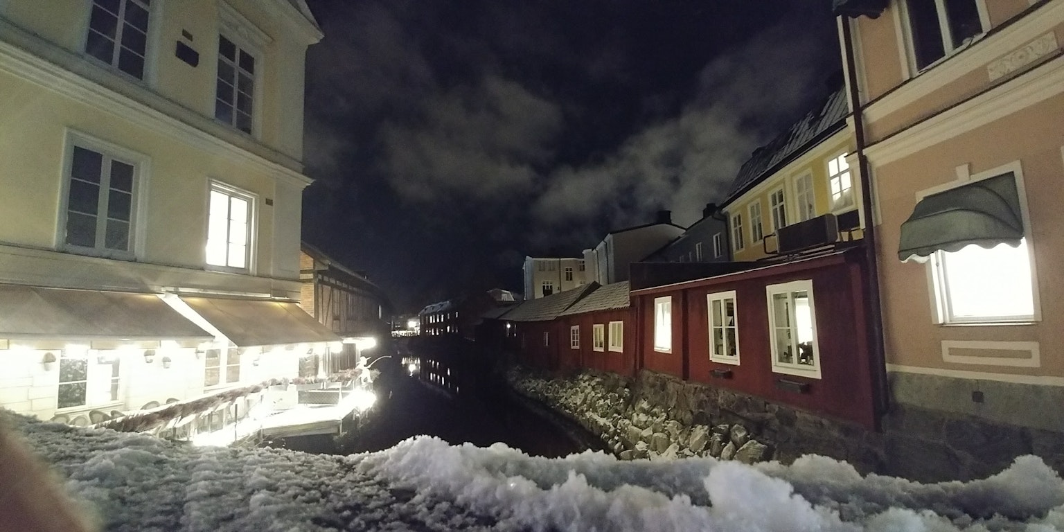 雪覆盖的运河夜景 红色和白色建筑的对比