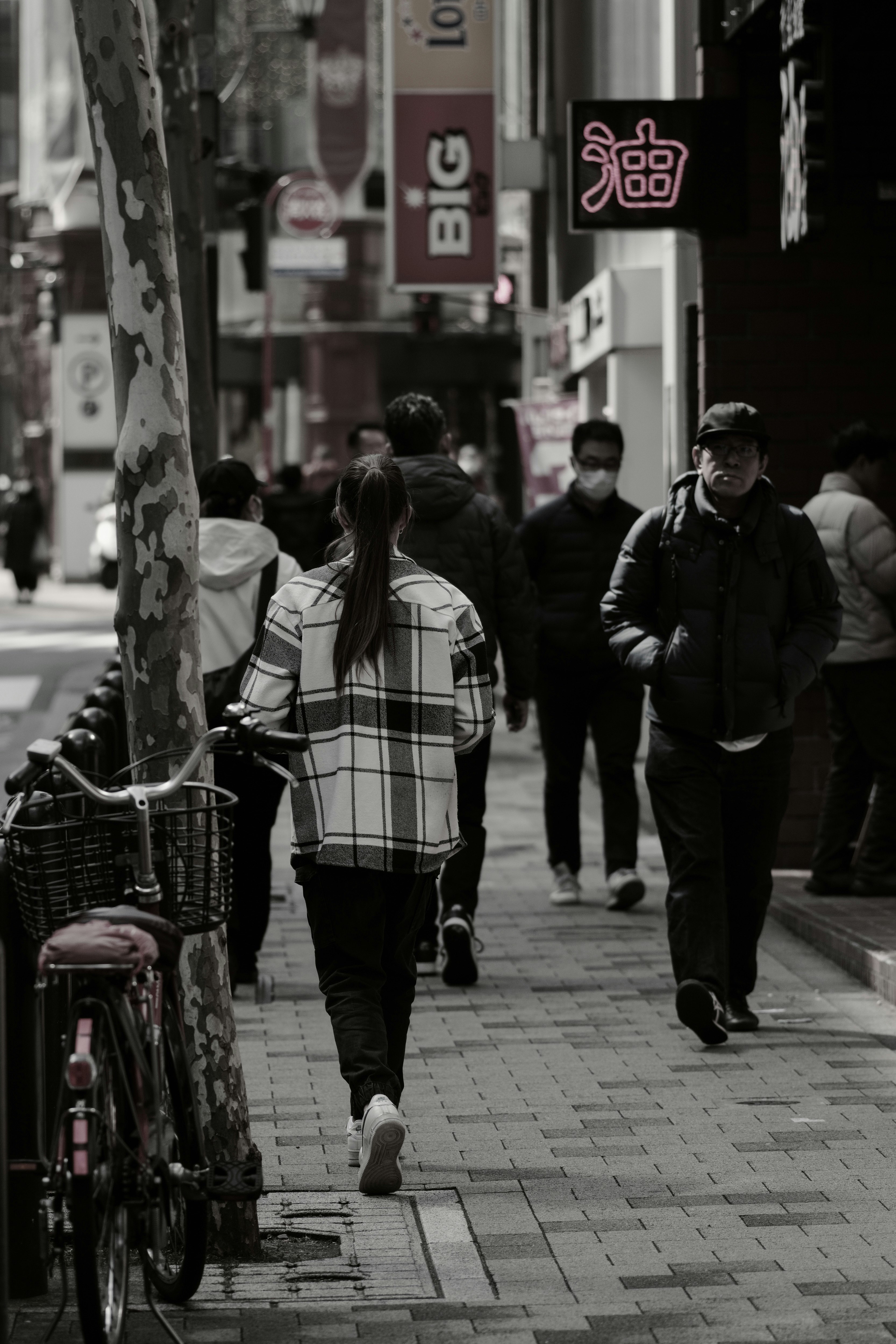 東京の路地を歩く人々と自転車のある街並み