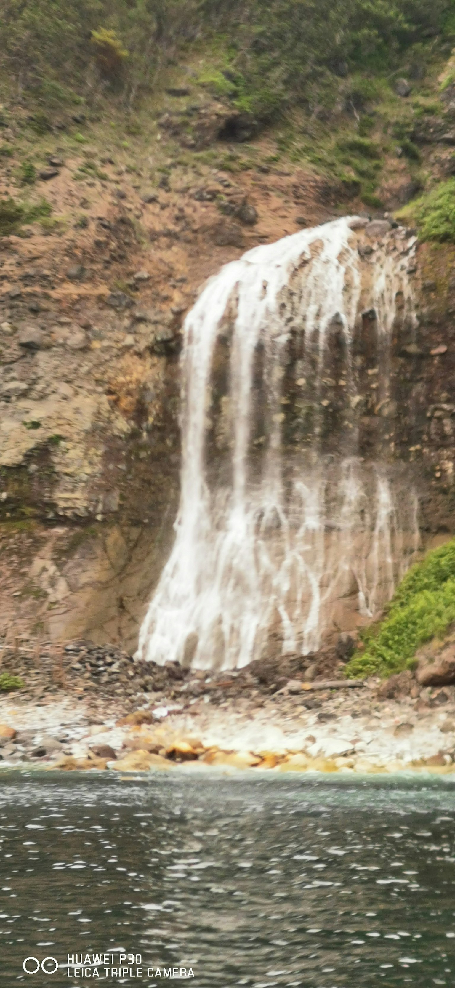 Una hermosa cascada que cae por un acantilado rocoso en un paisaje natural