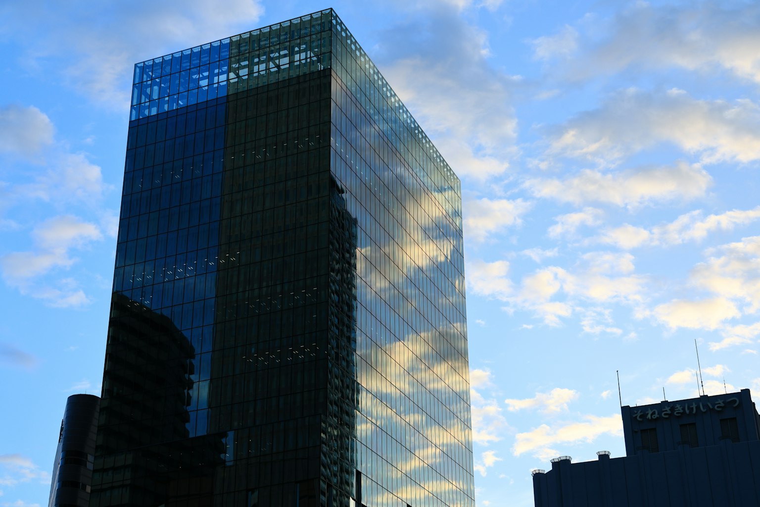 High-rise building with glass facade reflecting the blue sky