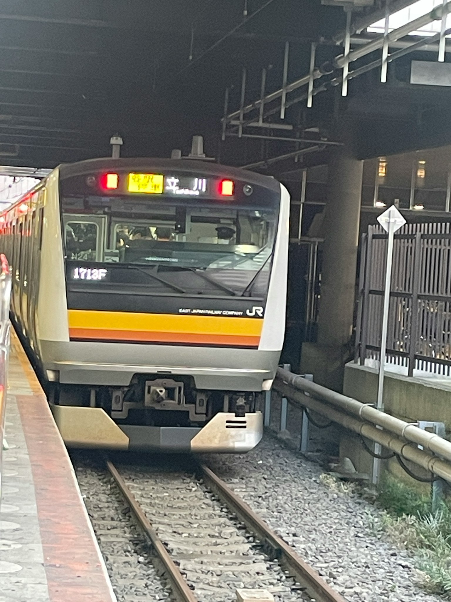 Train arriving at a station with visible LED display on the front
