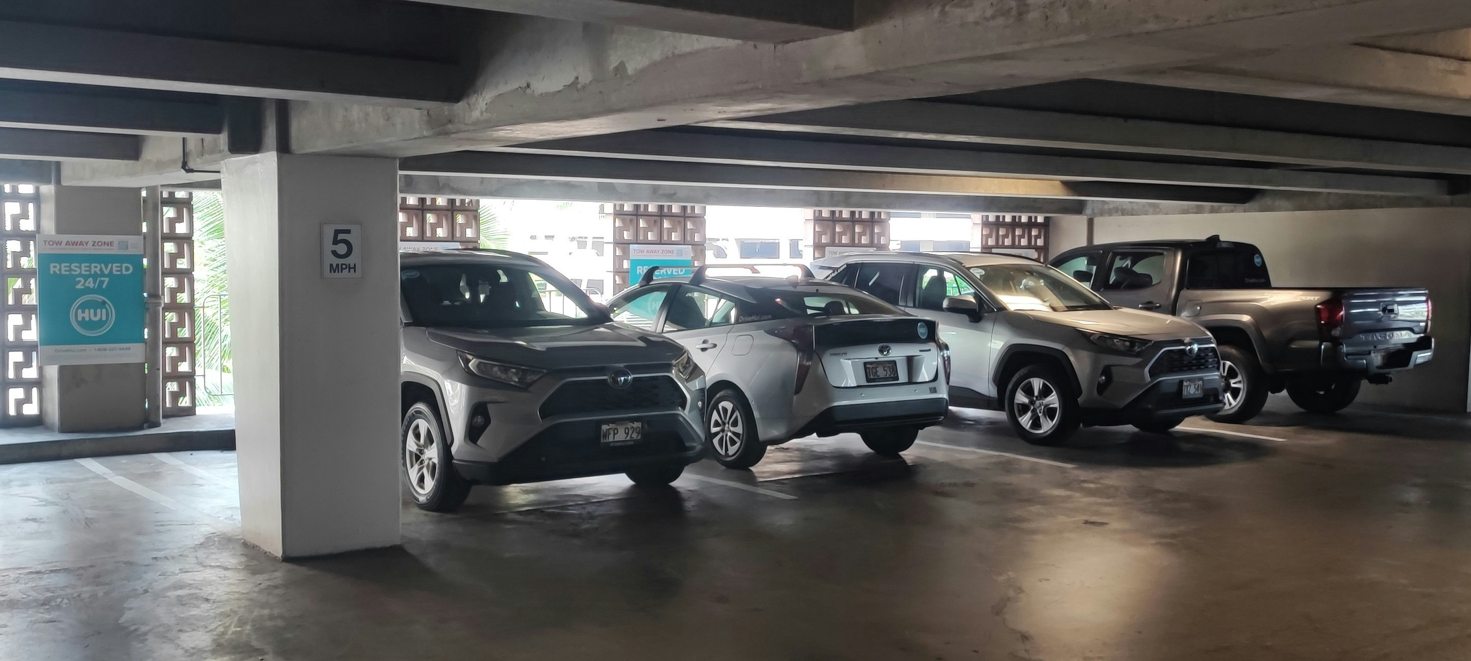 garage parking space with cars lined up in an underground lot
