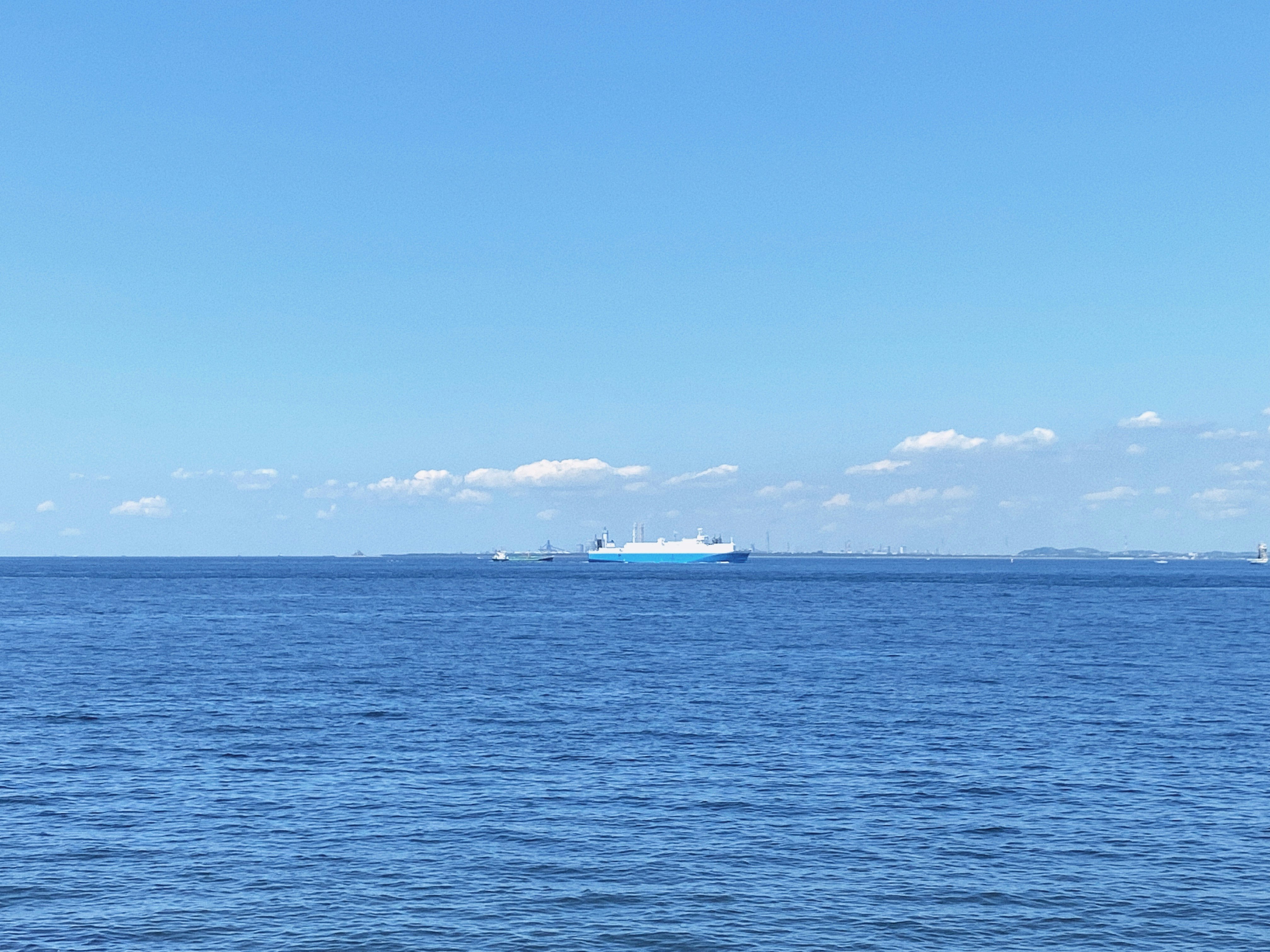 水平線に浮かぶ大型客船のある青い海の風景