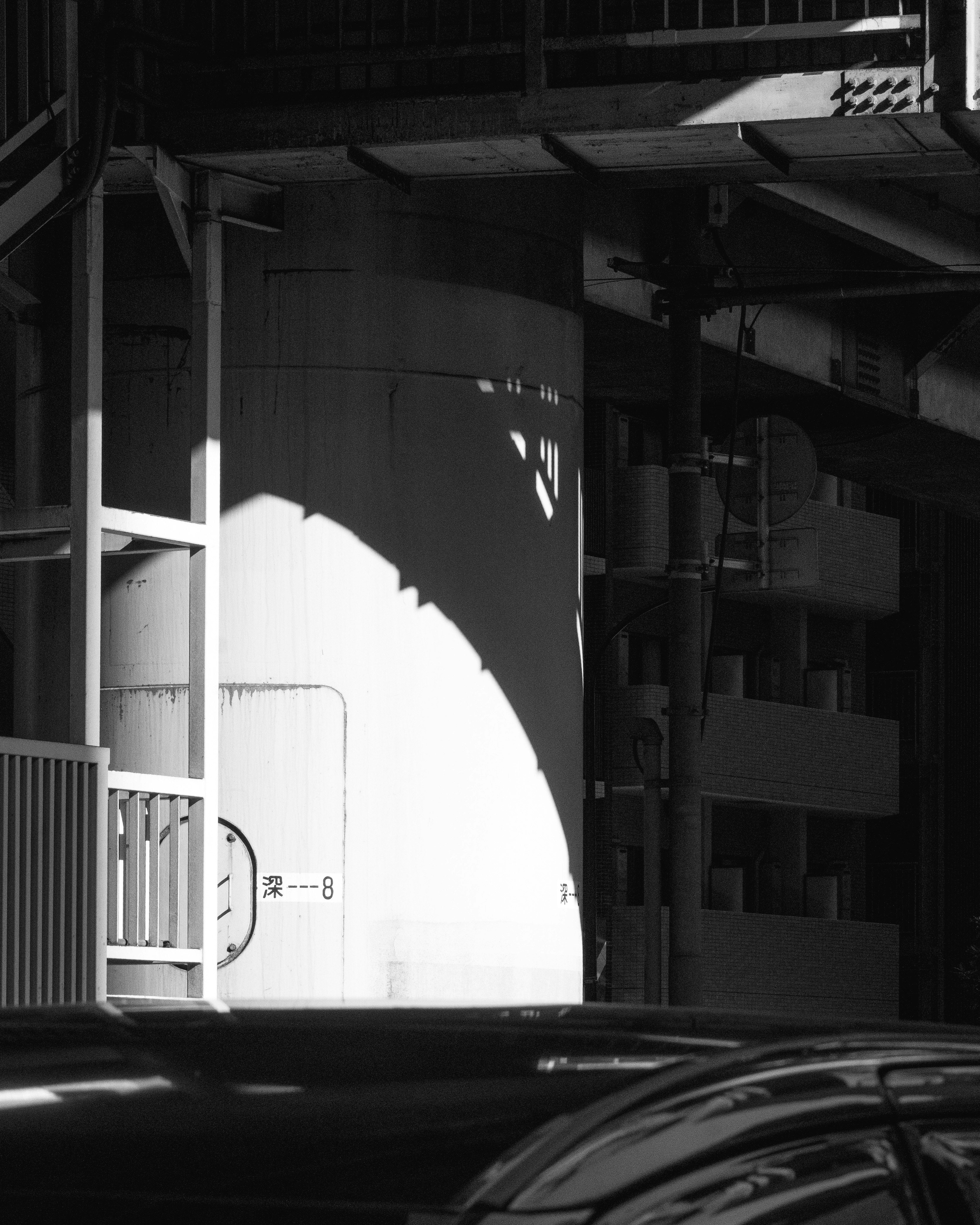 アーチ状の光が差し込む倉庫の通路と車