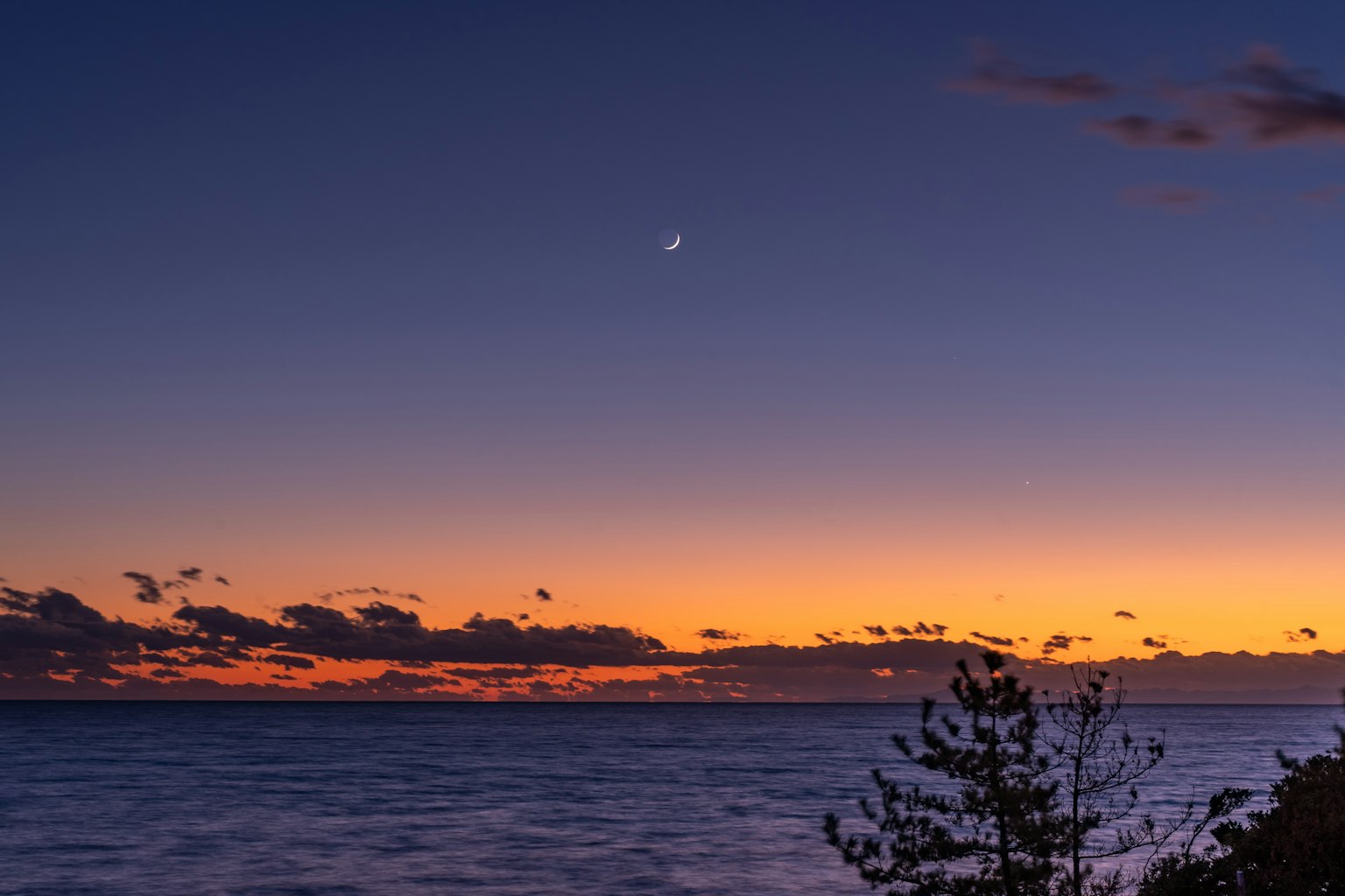 Twilight ocean view with crescent moon