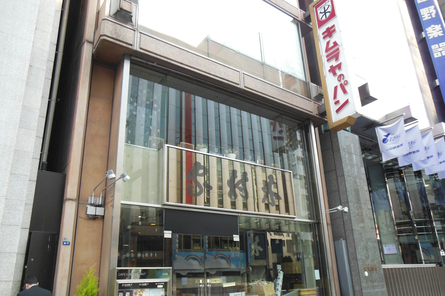 Fachada moderna con grandes ventanales y un letrero japonés en la parte superior
