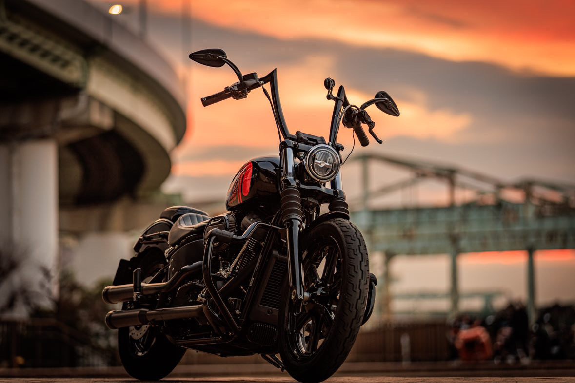 motocicletta parcheggiata sotto una struttura sopraelevata al tramonto