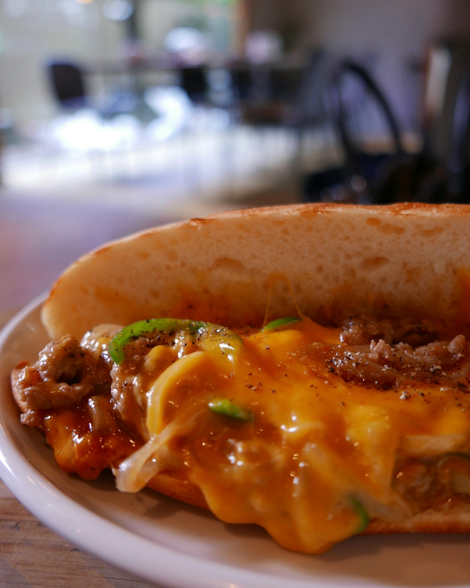 Un hot dog farcito con formaggio e condimenti servito su un piatto