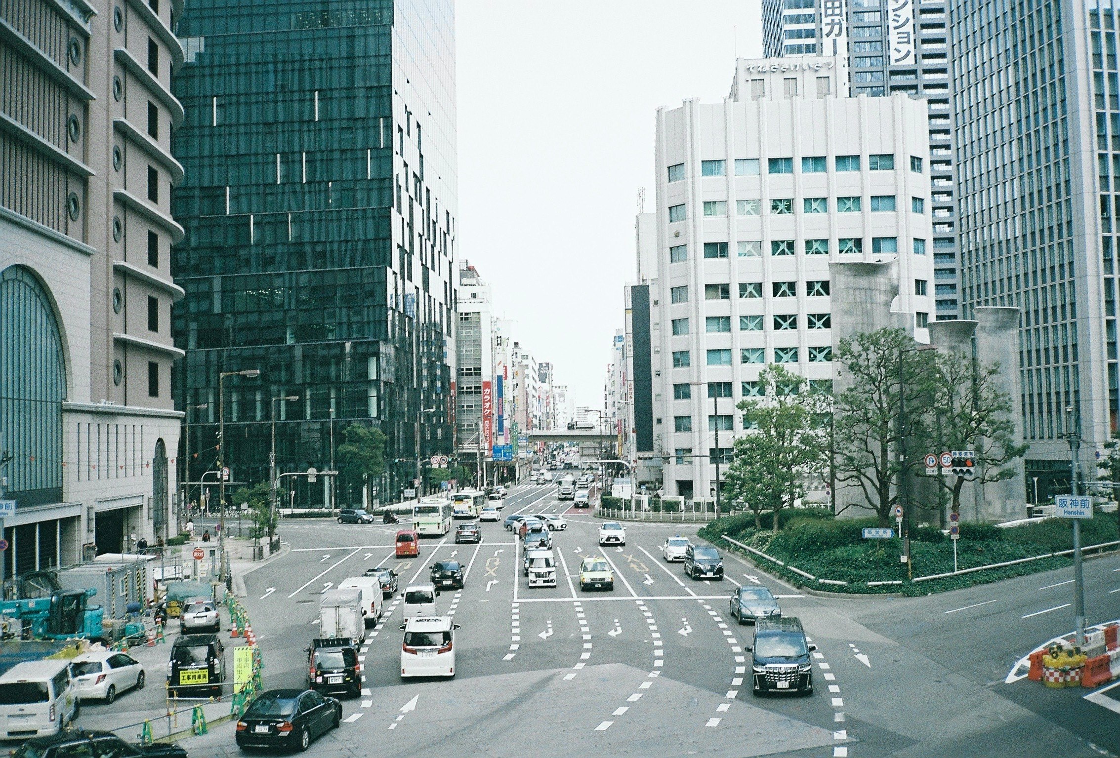 Viale cittadino con auto tra alti edifici