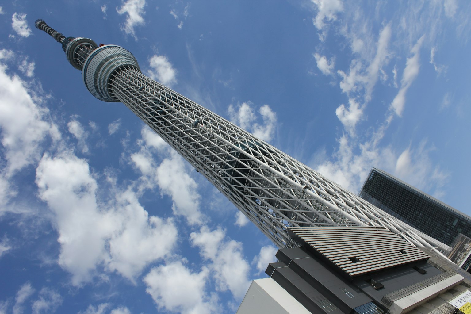 Bild des Tokyo Skytree aus einem diagonalen Winkel blauer Himmel und weiße Wolken im Hintergrund