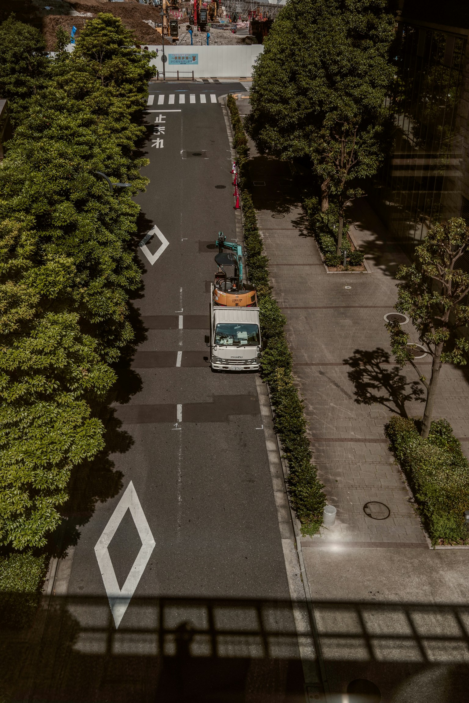 Truck parked on a quiet street surrounded by green trees