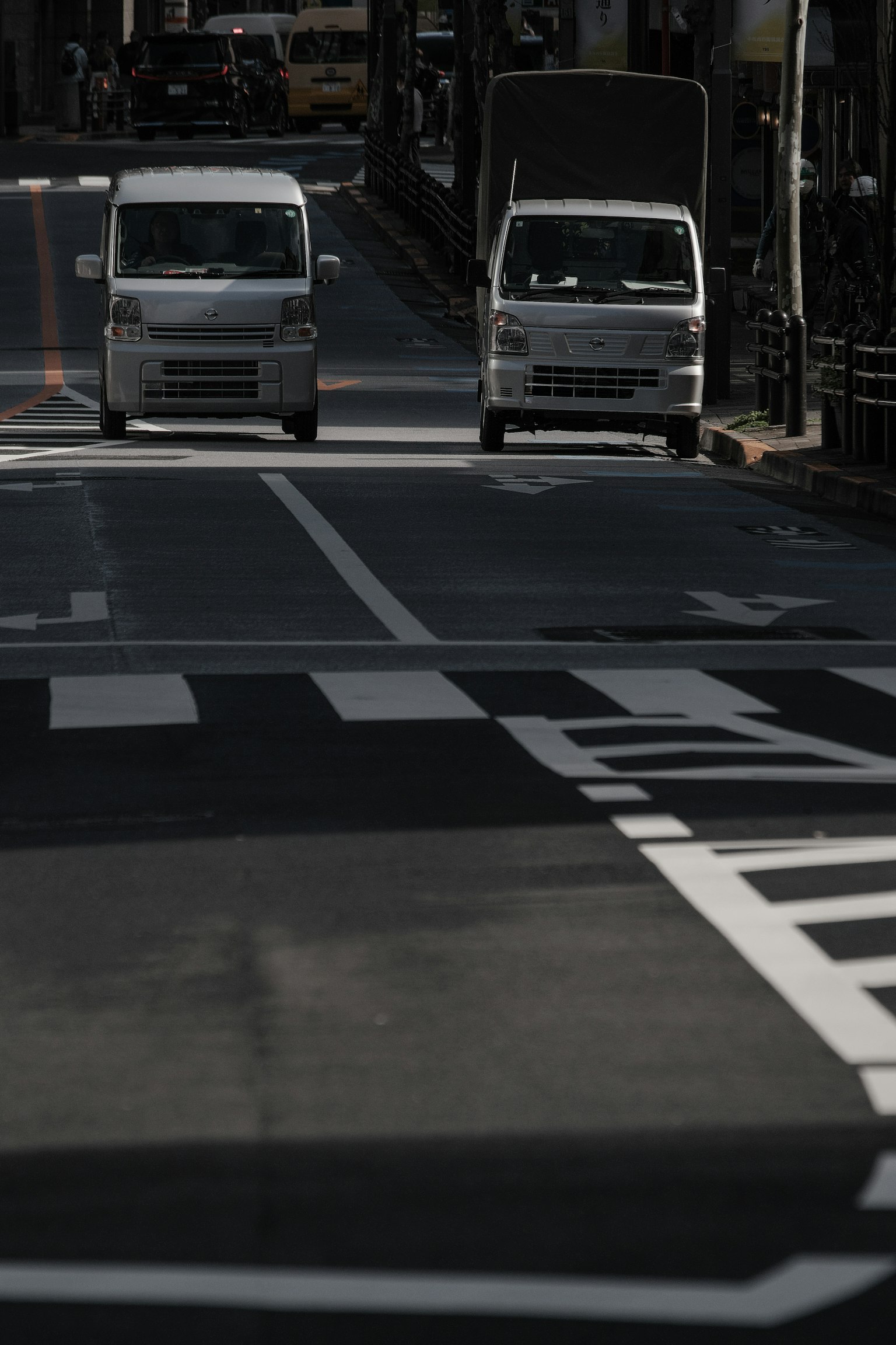 ภาพของรถบรรทุกขนาดเล็กสองคันบนถนนที่มีแสงน้อย