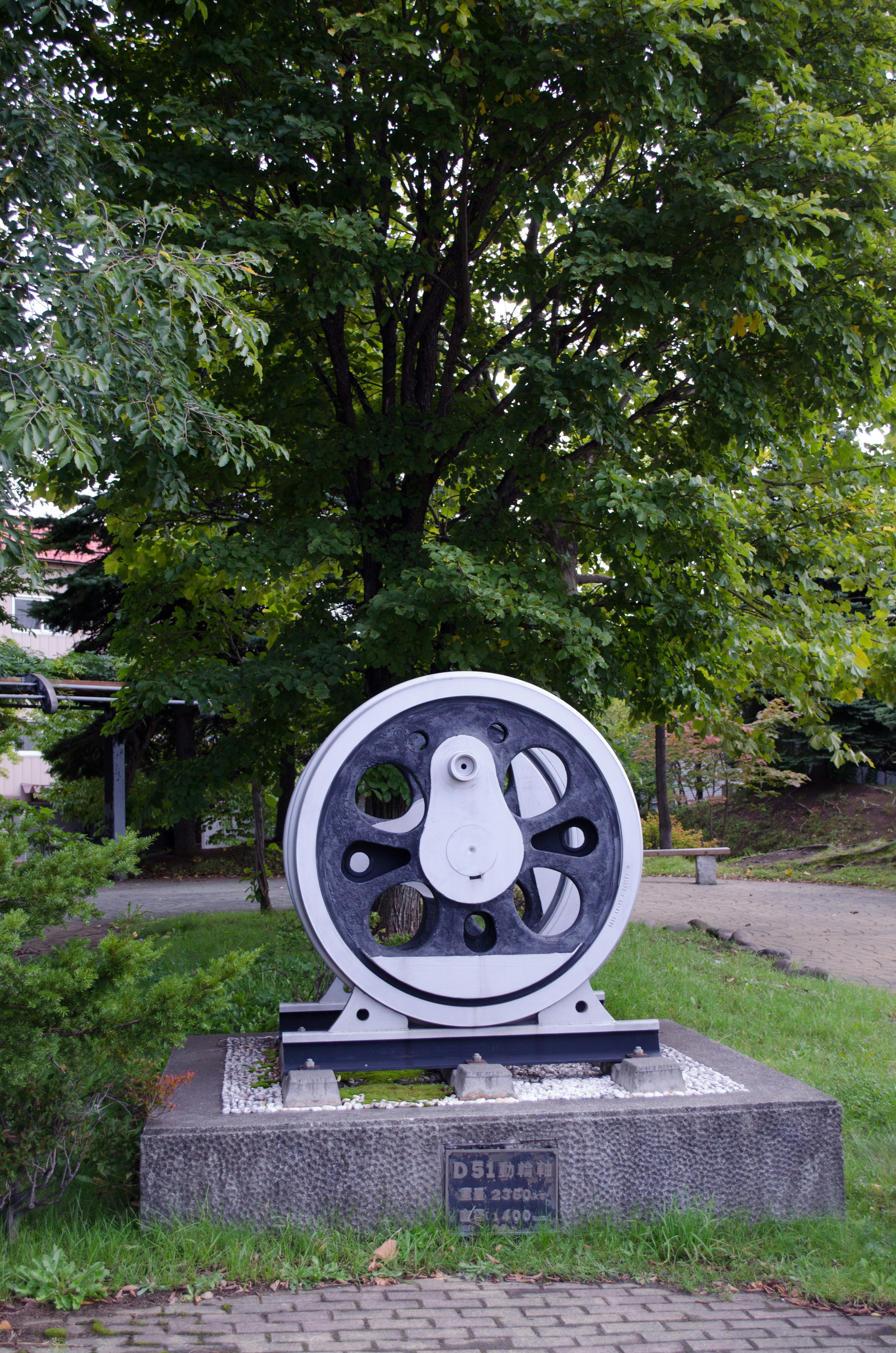 park lawn display of an old mechanical wheel-like exhibit