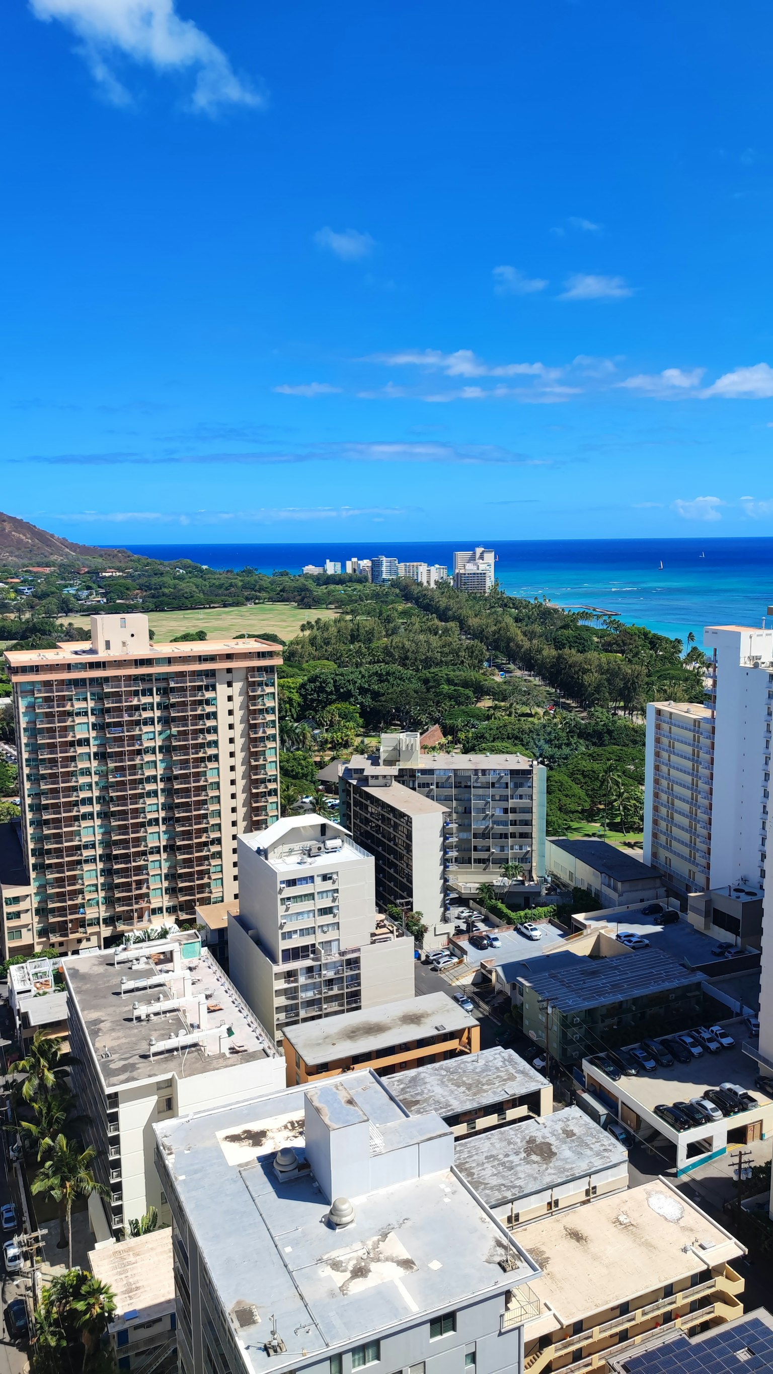 ทิวทัศน์พาโนรามาของมหาสมุทรสีน้ำเงินและตึกสูงโดยมี Diamond Head อยู่ไกลออกไป