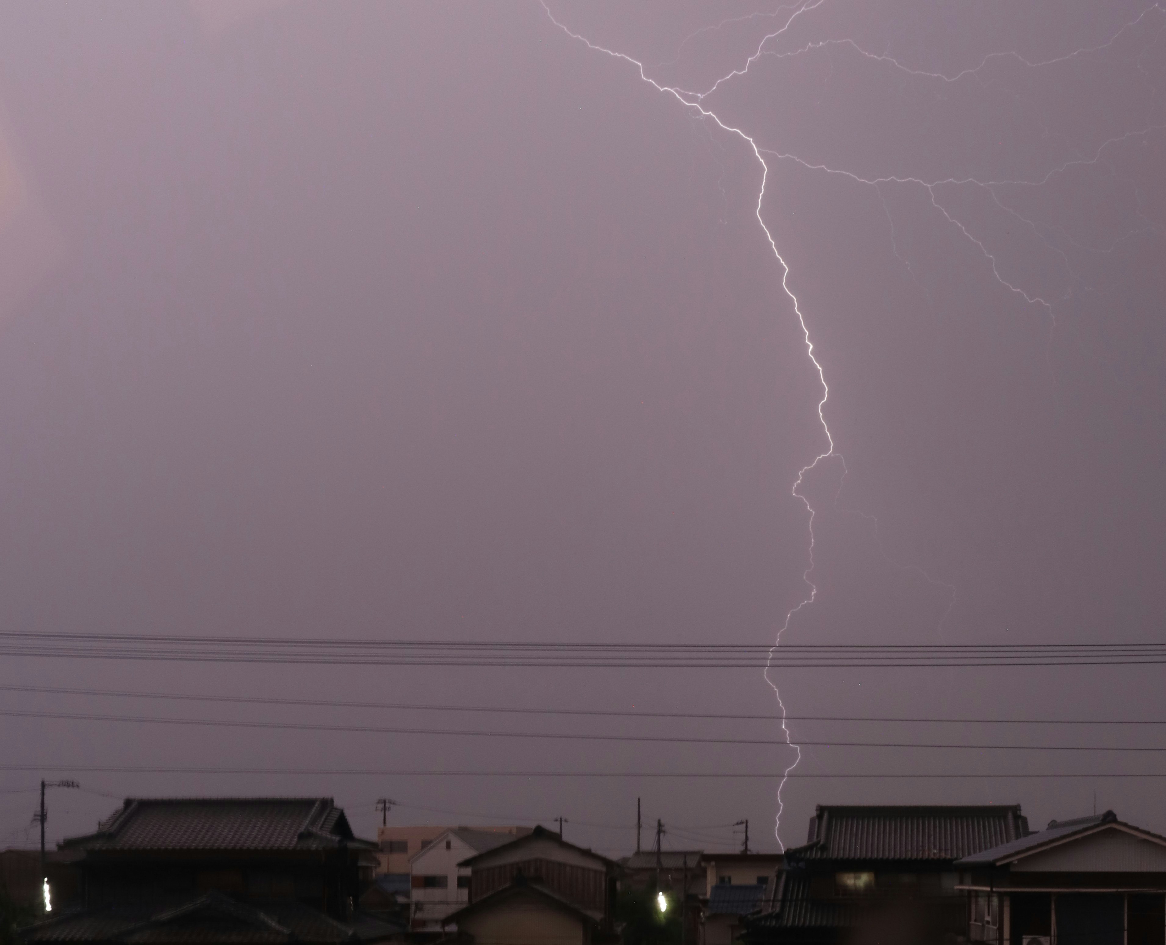 雷鳴の稲妻が空を走る嵐の夜の住宅街