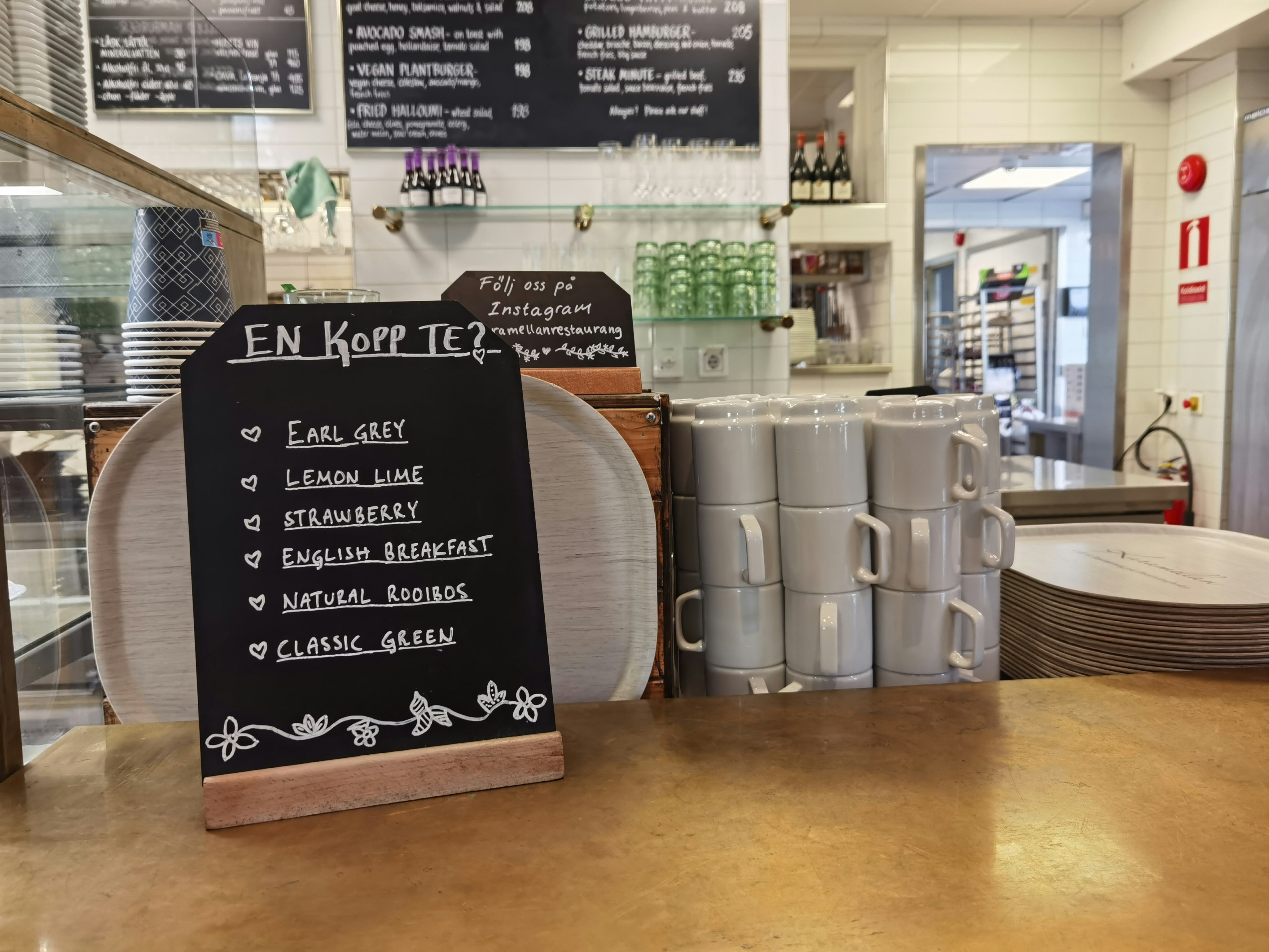cafe counter with chalkboard menu and stacked cups
