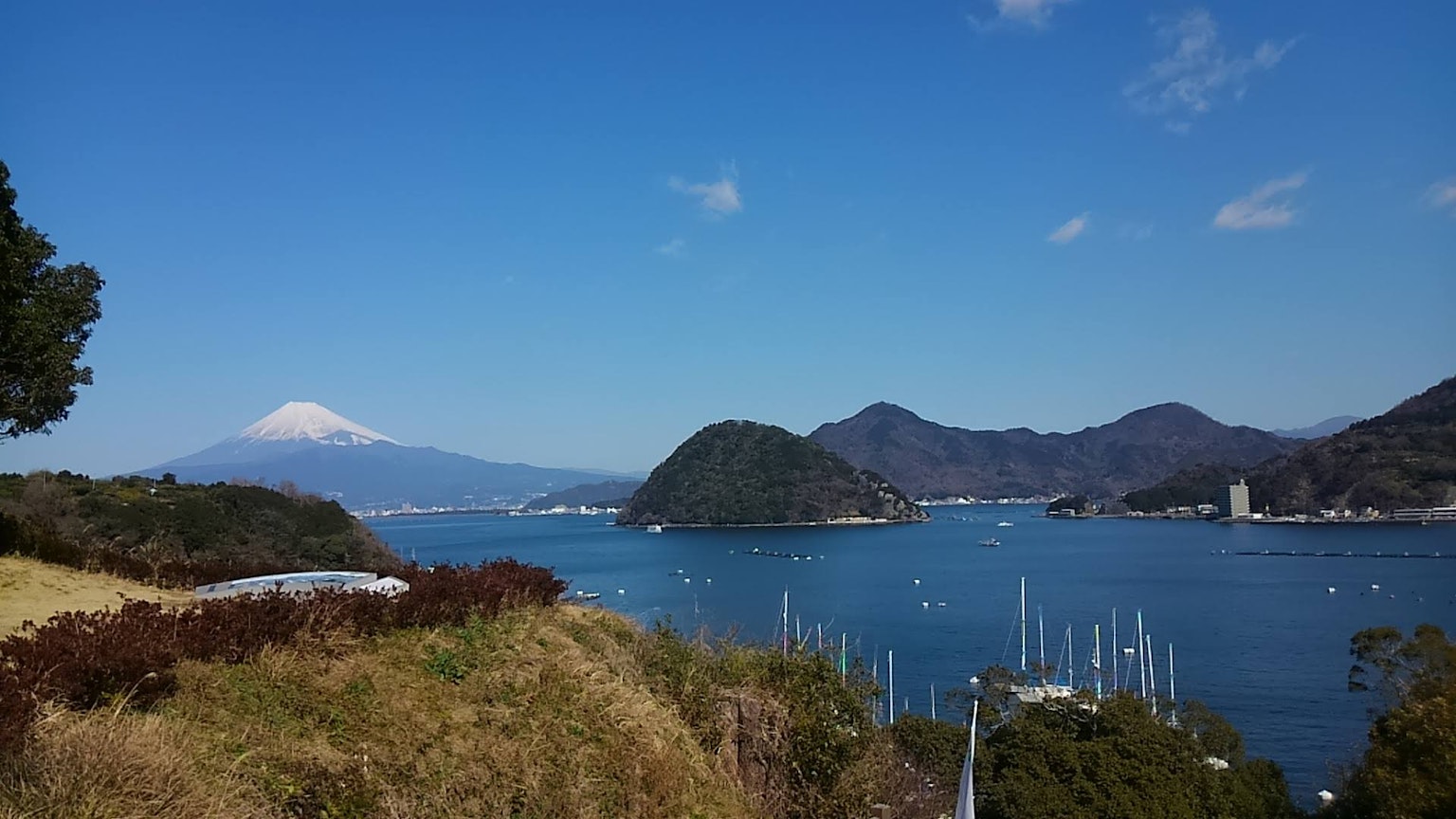 Vista escénica del mar y las montañas con el monte Fuji a lo lejos