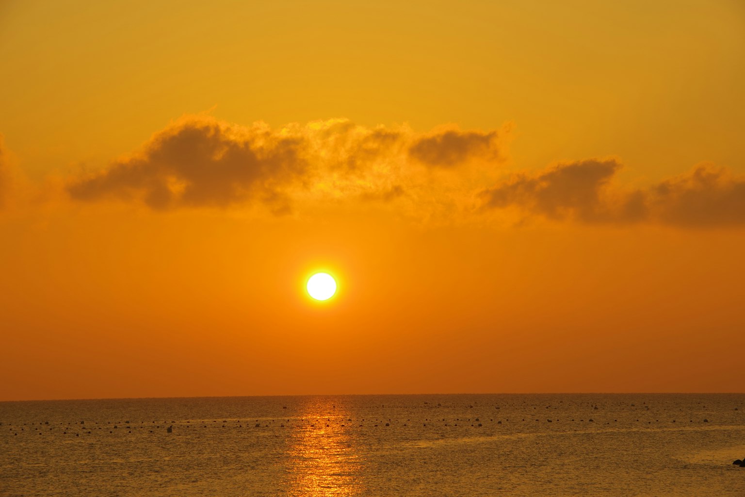 Atardecer sobre el océano con tonos naranjas y agua reflectante