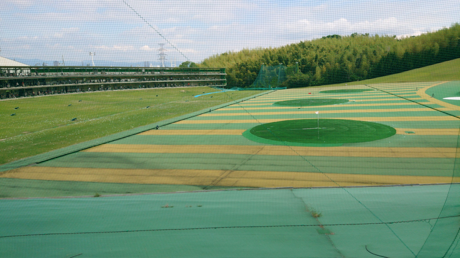 Green golf driving range with fairway and target areas