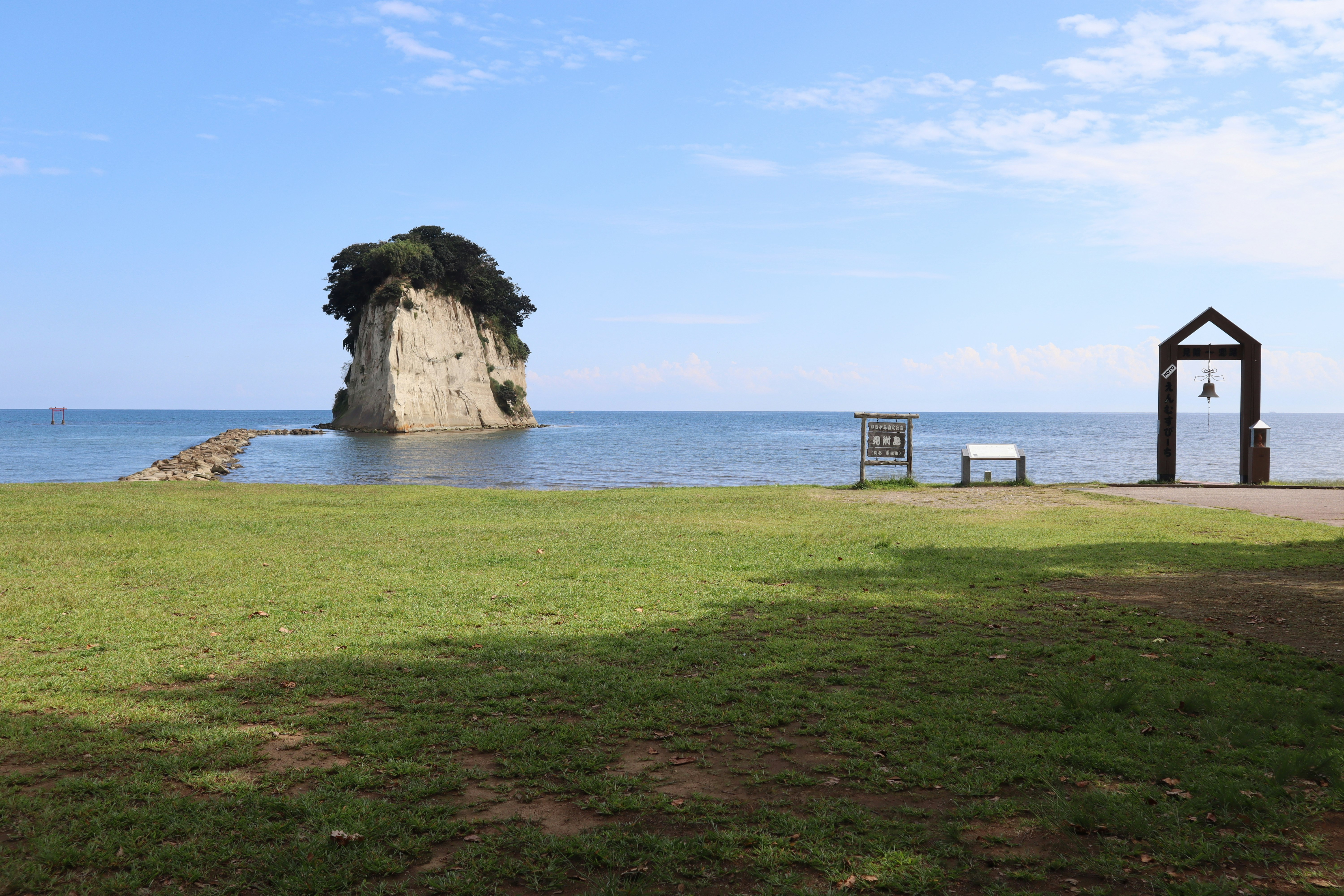 草地と海を望む岬の景色と小さな礼拝堂