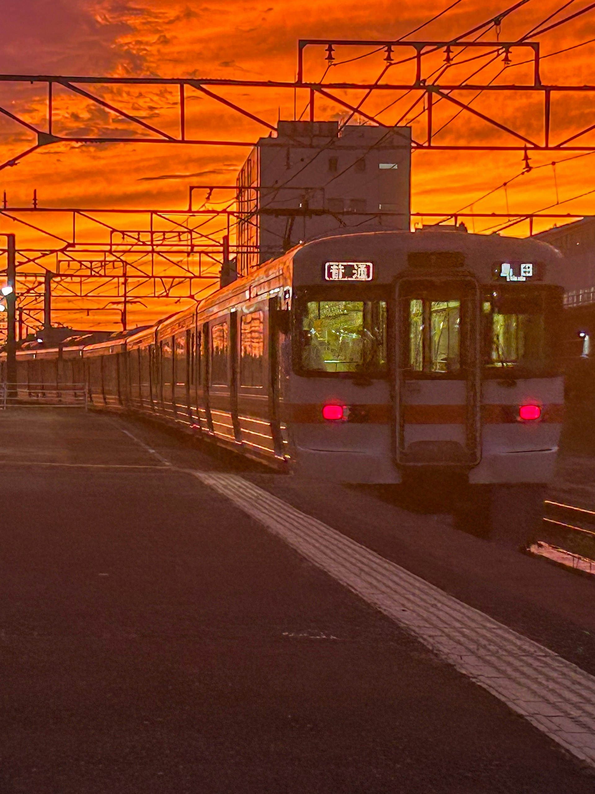 夕焼けの中を走る電車の車両と線路