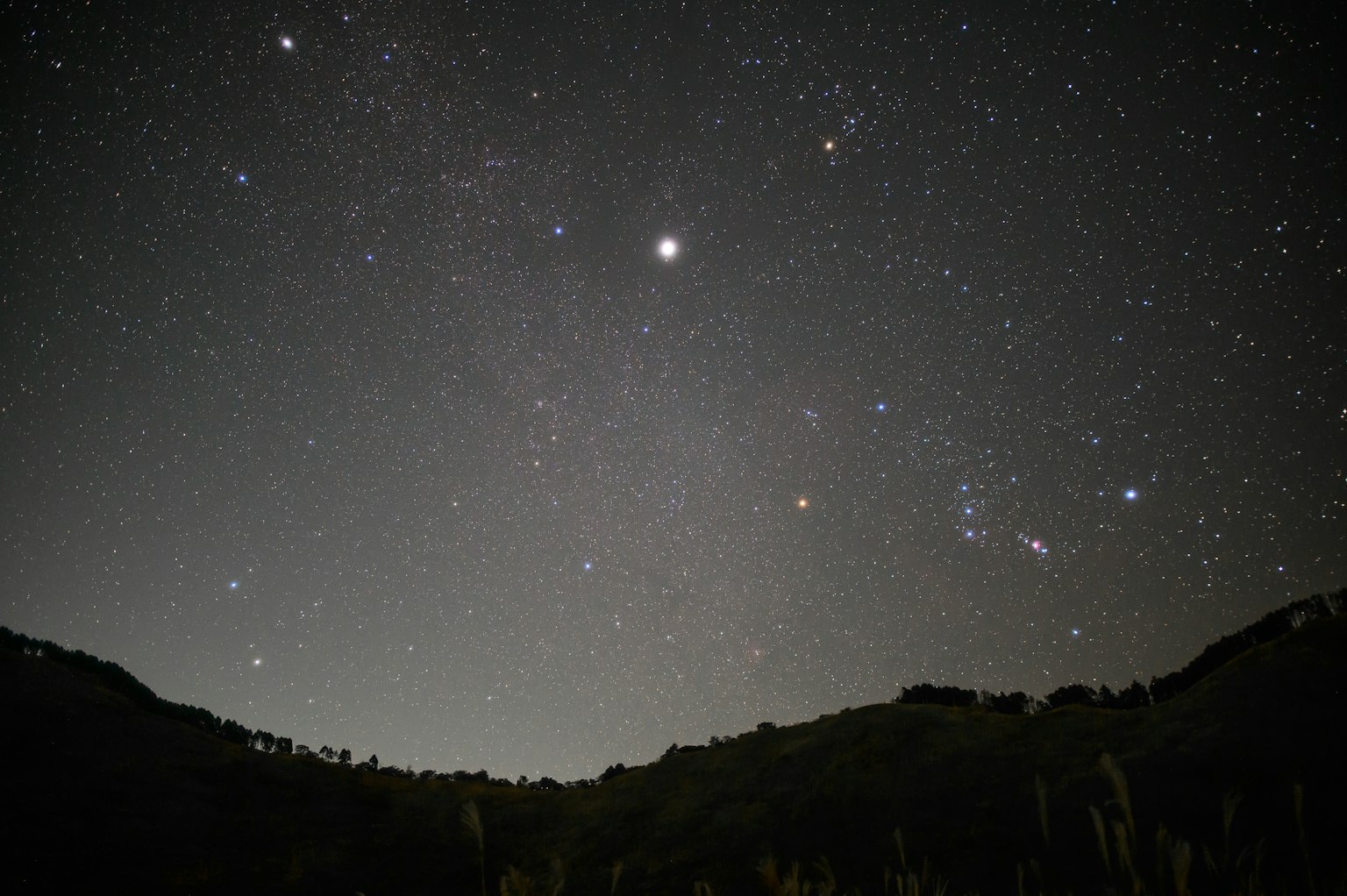 Ciel étoilé avec des étoiles brillantes et silhouette de montagne