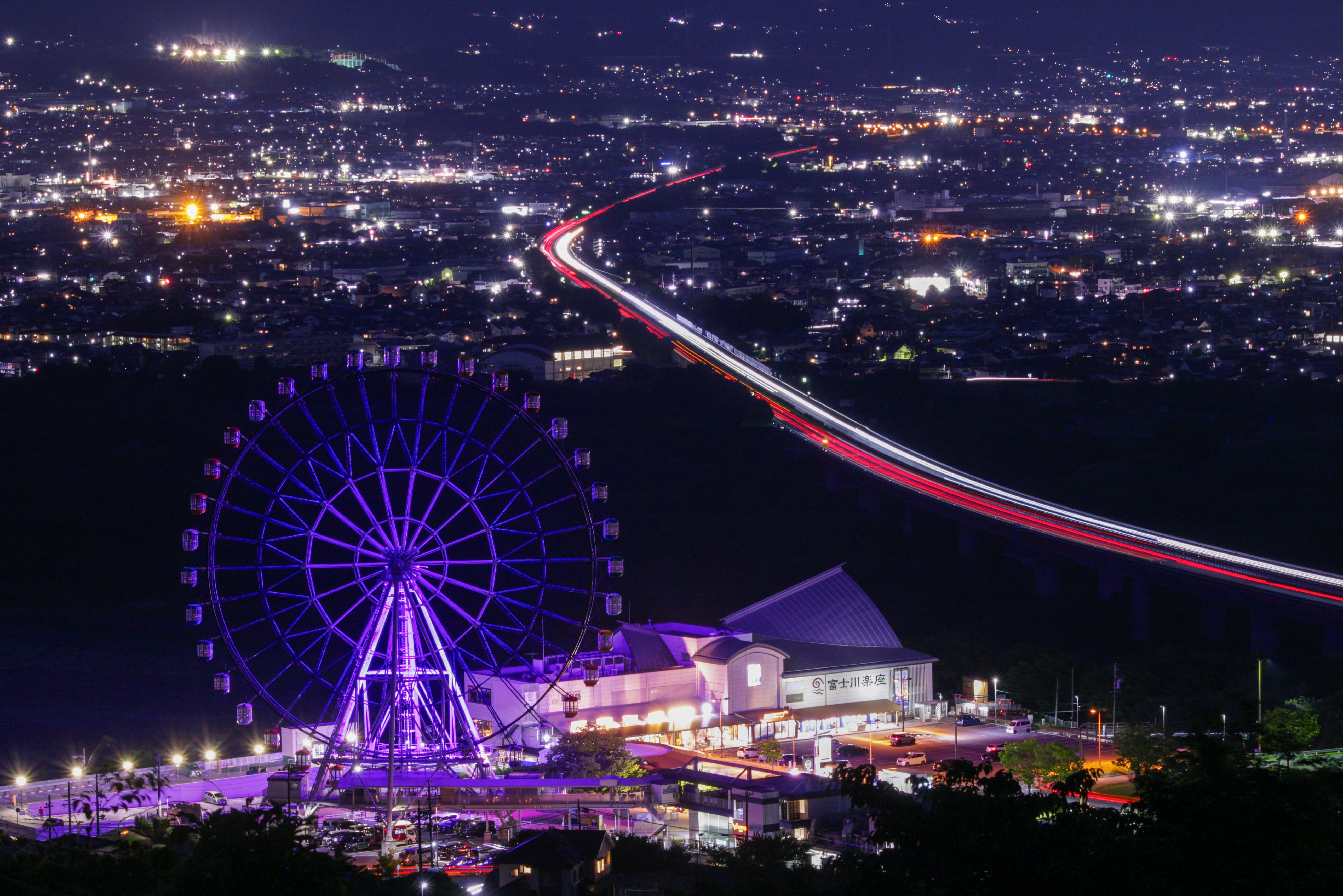夜景の観覧車と街の光が広がる風景