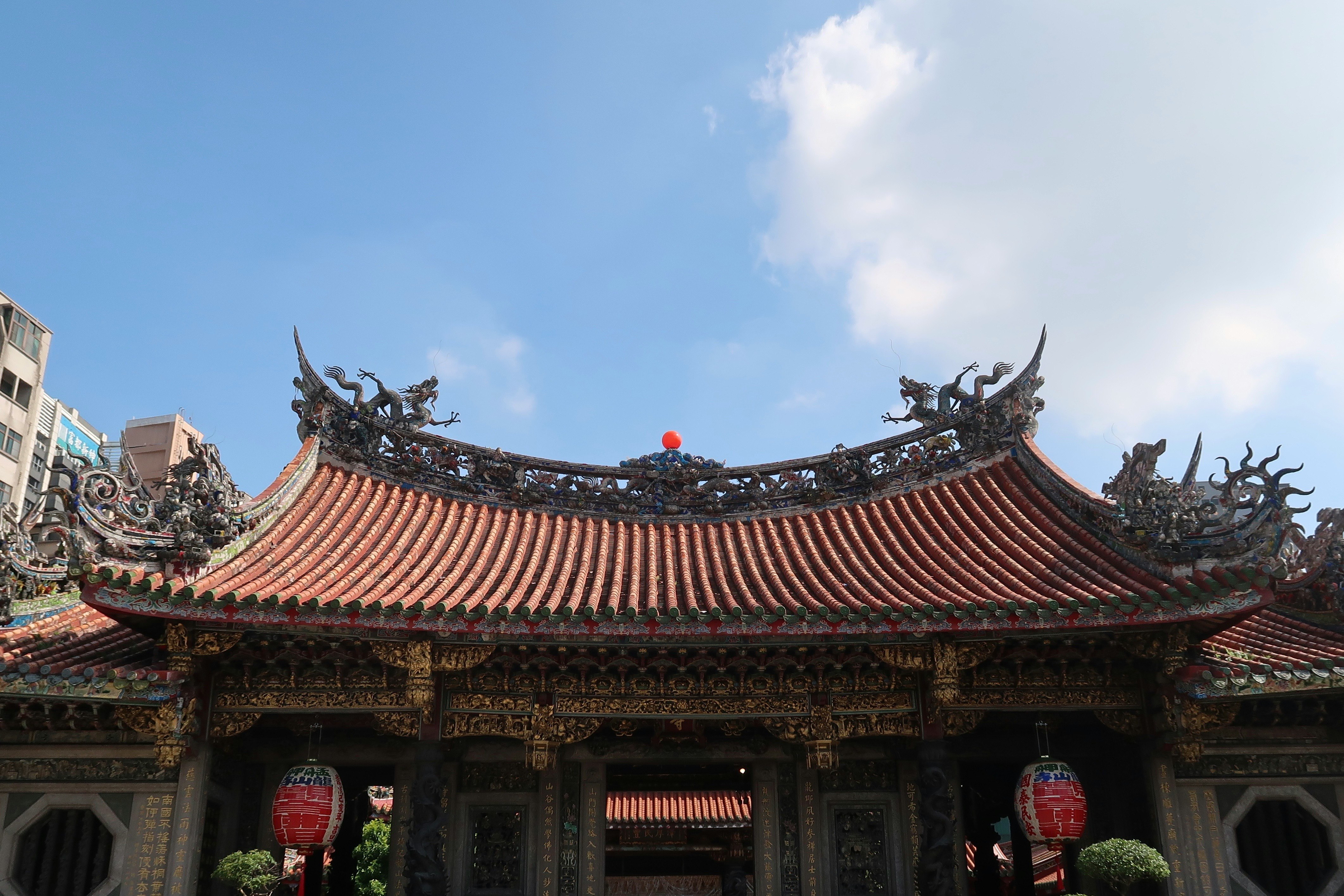 Brown upturned-tile temple roof under a summer sky