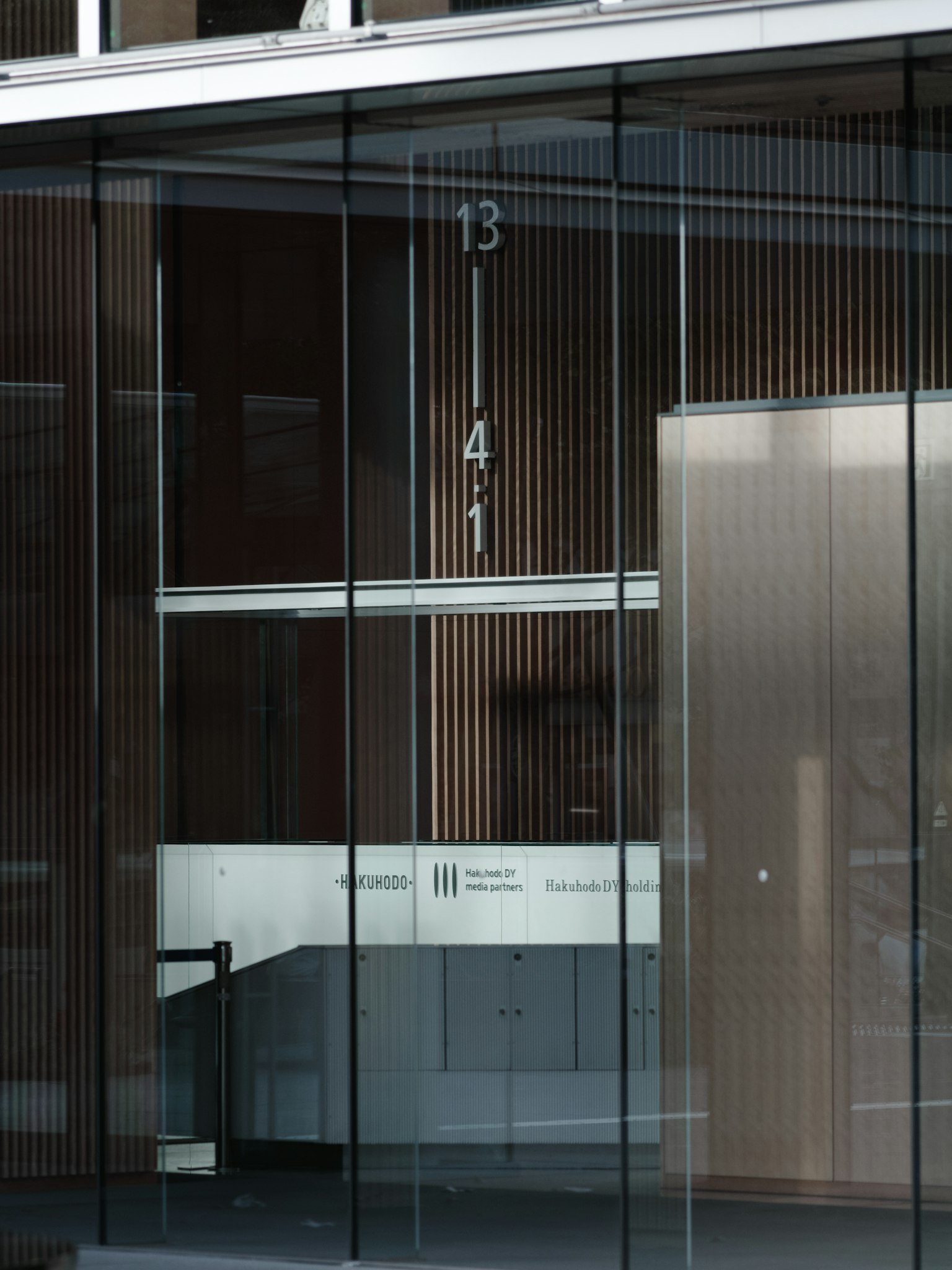 Entrance of a modern building with glass facade displaying the numbers 3 and 4