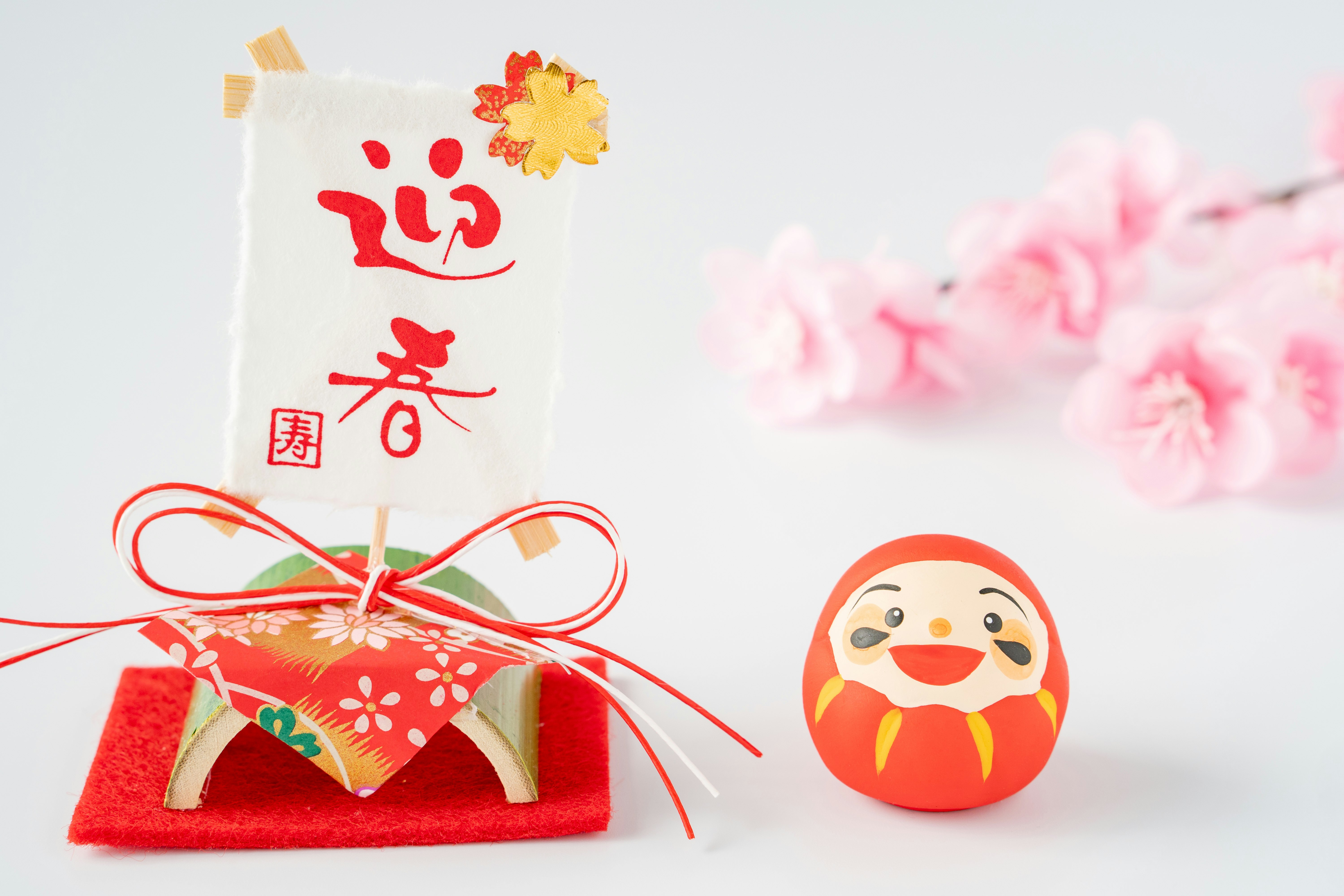 紅色日式幸運擺件與達摩小像，白色背景