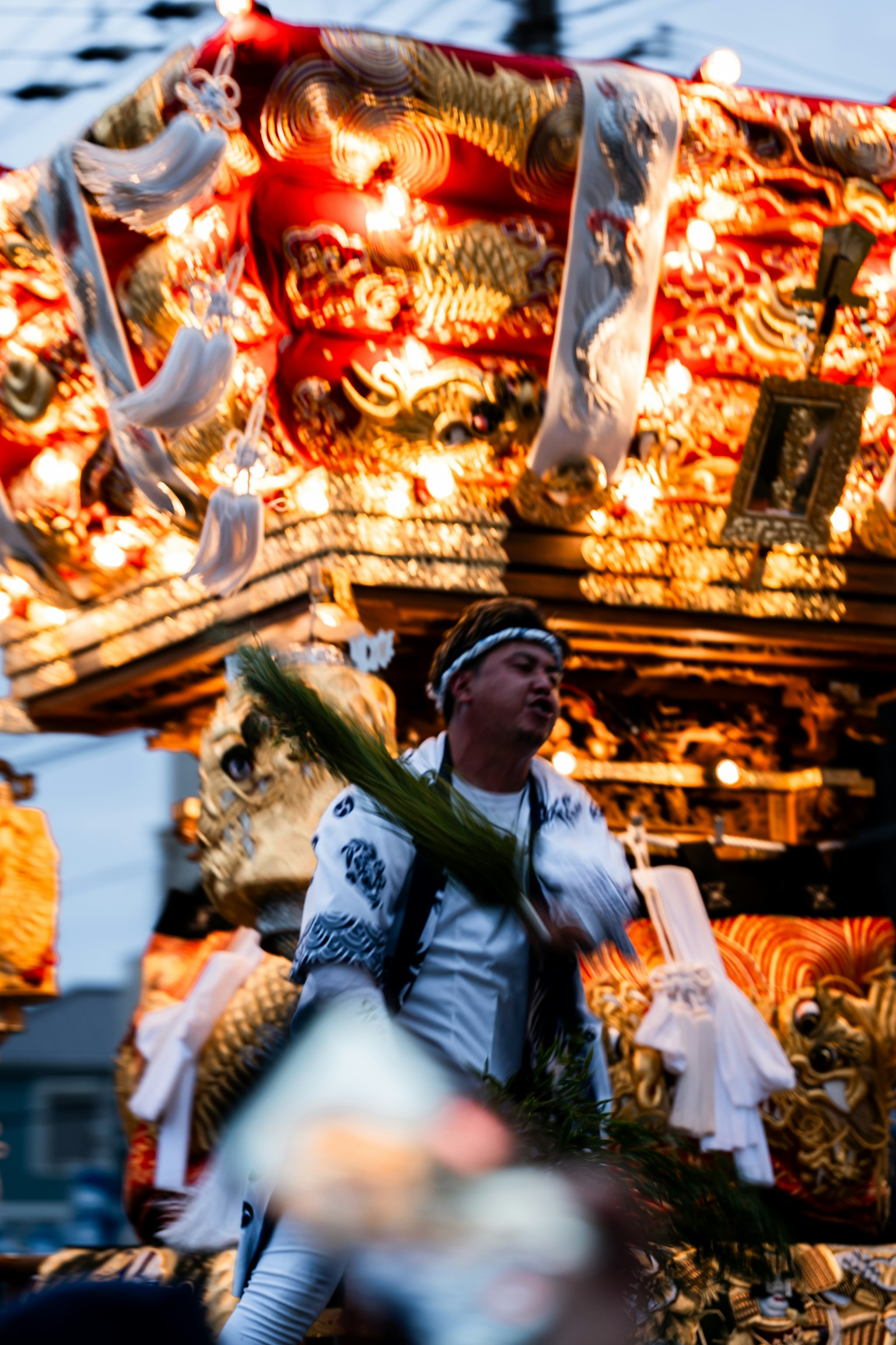 祭りの山車を引く男性が装飾された衣装を着ている