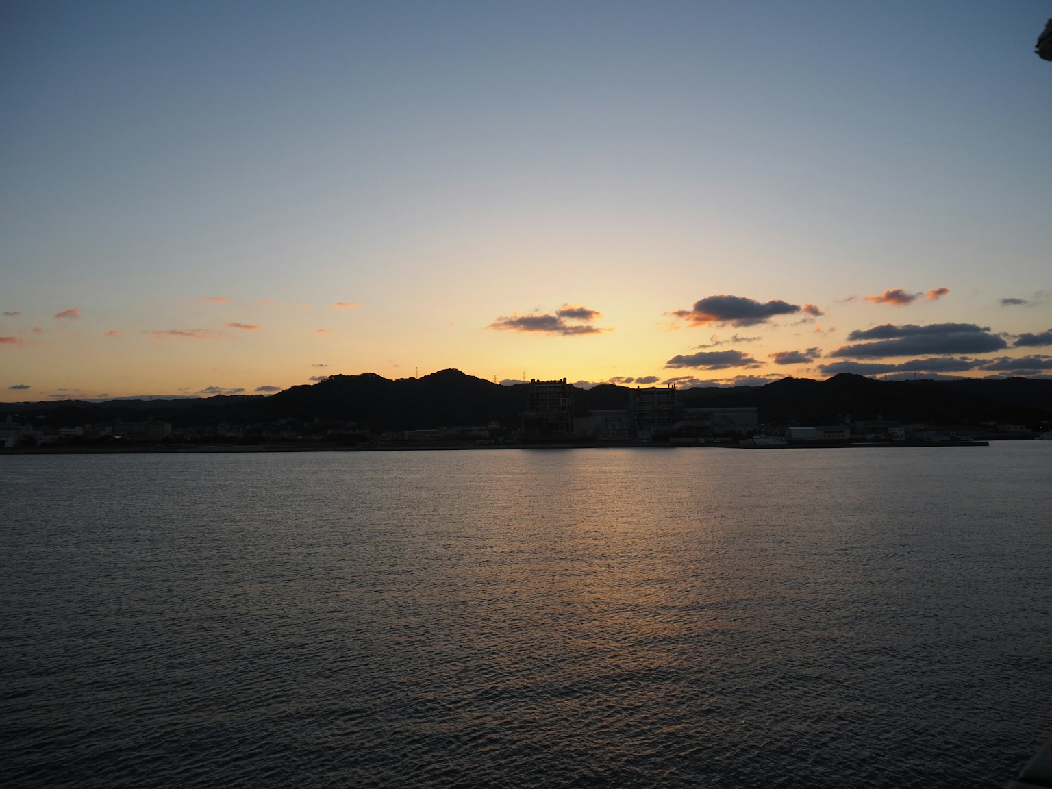 Sunset over the sea with distant mountains