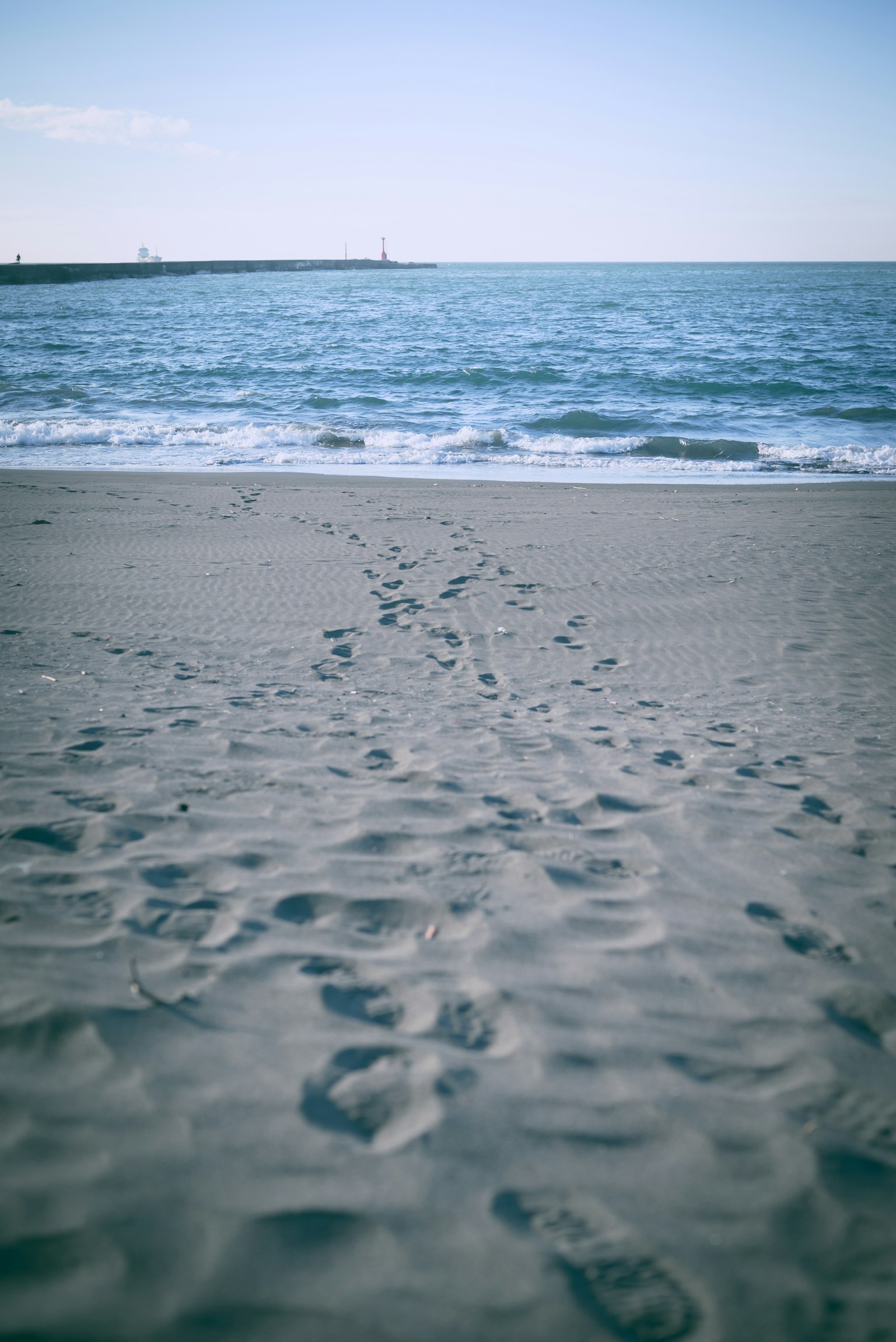 砂浜に残された足跡と青い海の風景