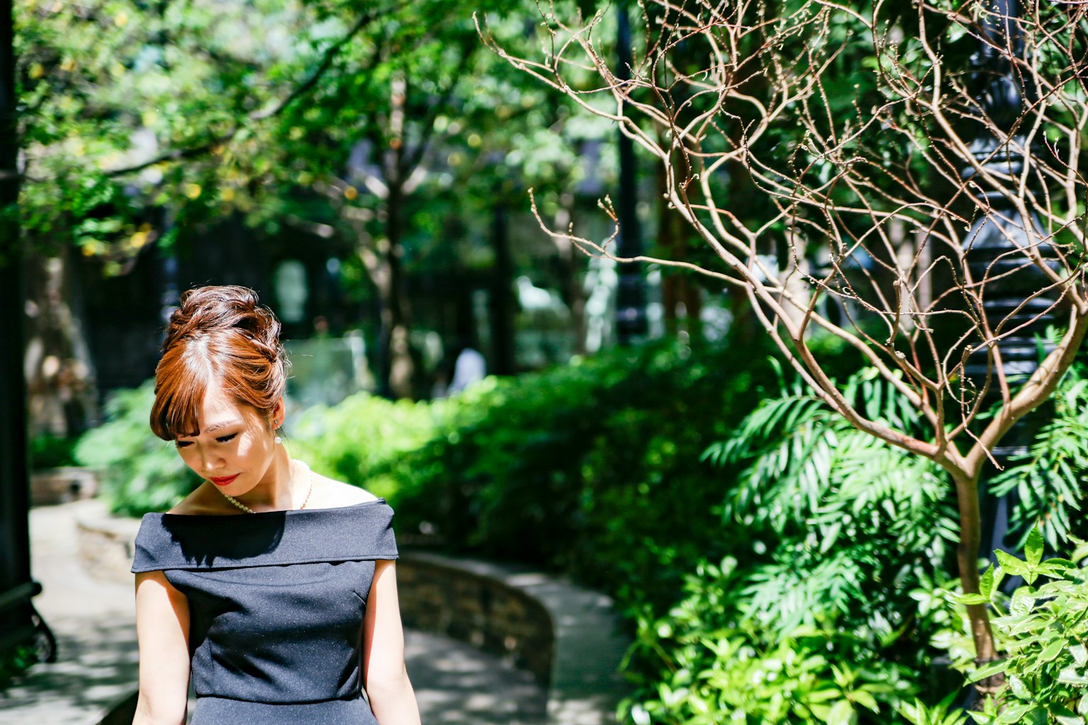 Portrait d'une femme entourée d'arbres verts portant une robe noire