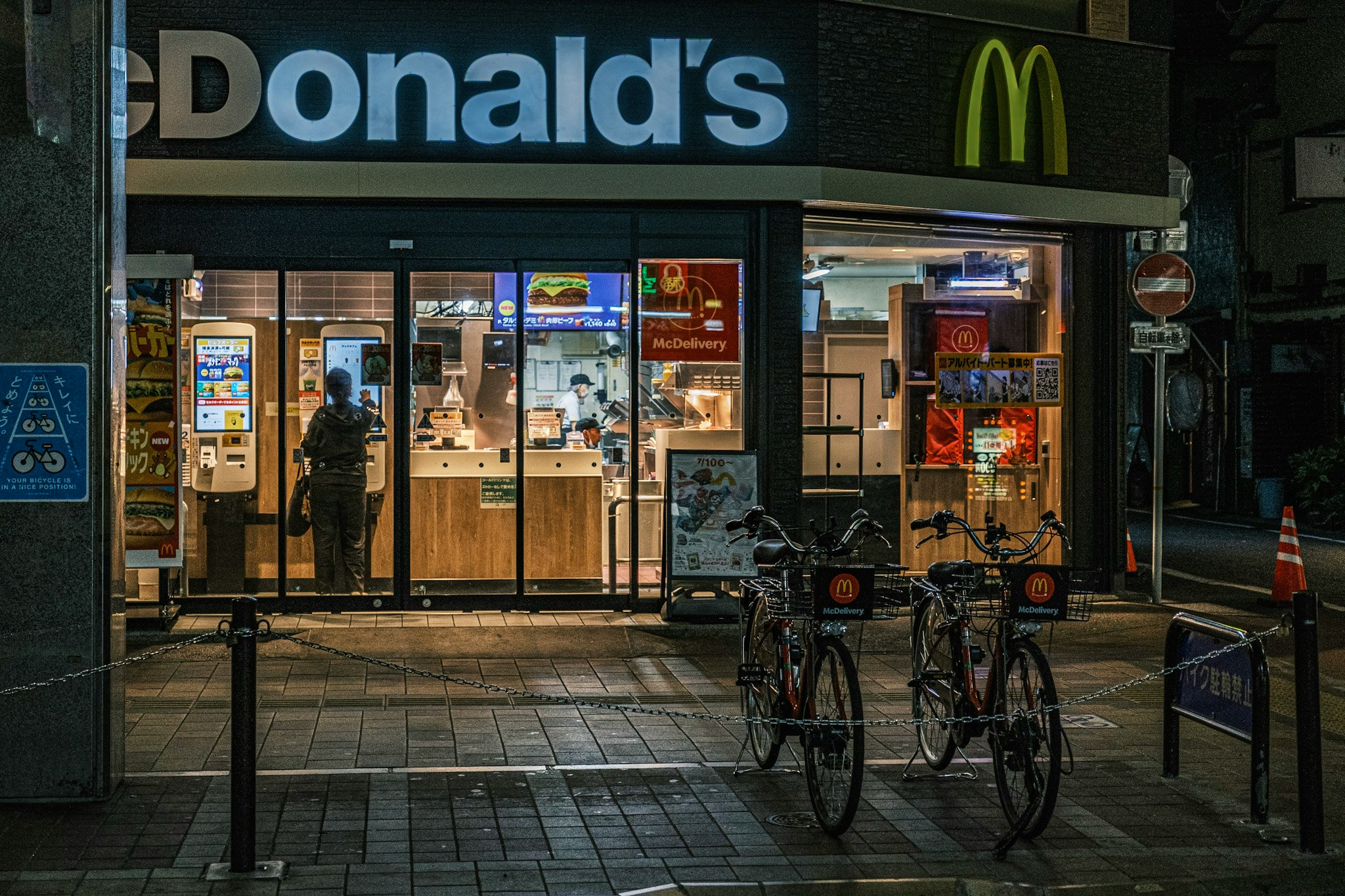 夜のマクドナルド前で自転車が並ぶ街角