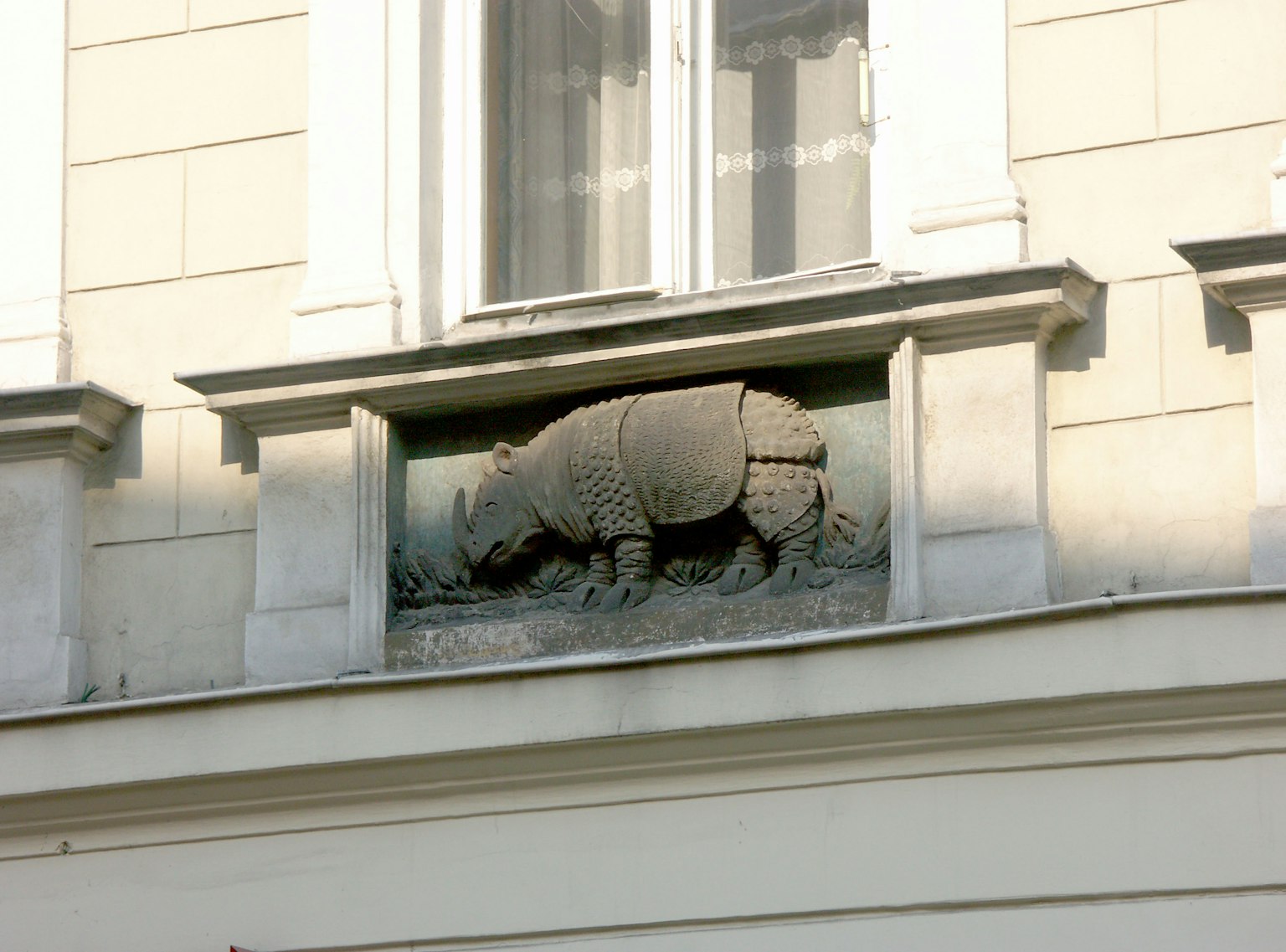 Scultura di un rinoceronte montata su un muro di edificio