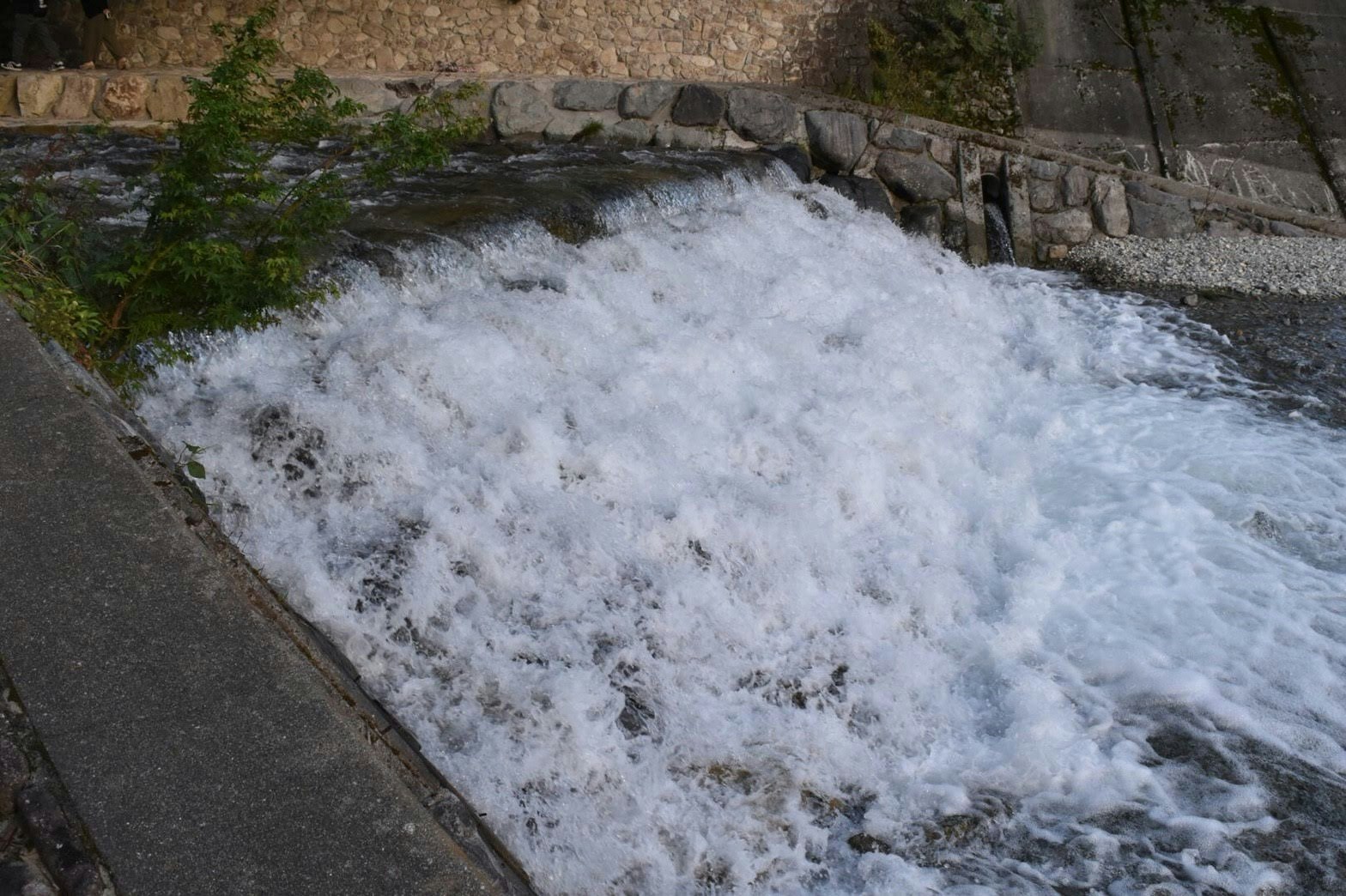 kraftvolles Flusswasser, das durch einen steinverkleideten Kanal fließt