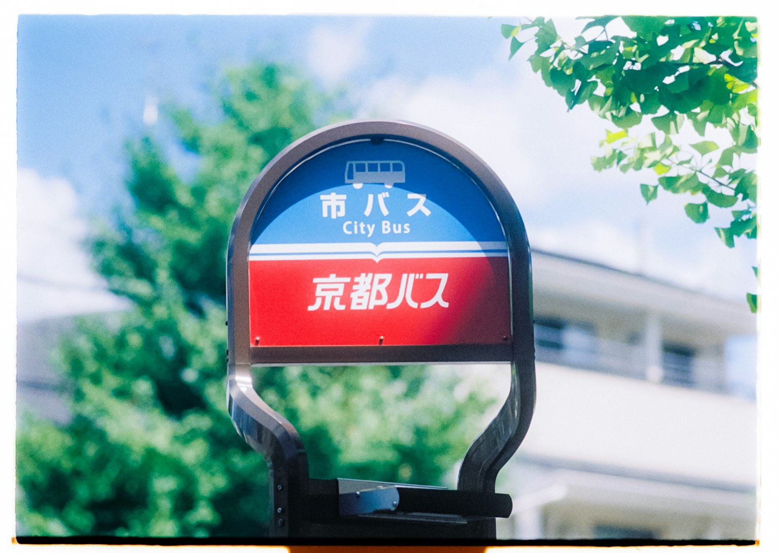 Bushaltestelle unter blauem Himmel mit Kyoto in auffälligen roten Buchstaben