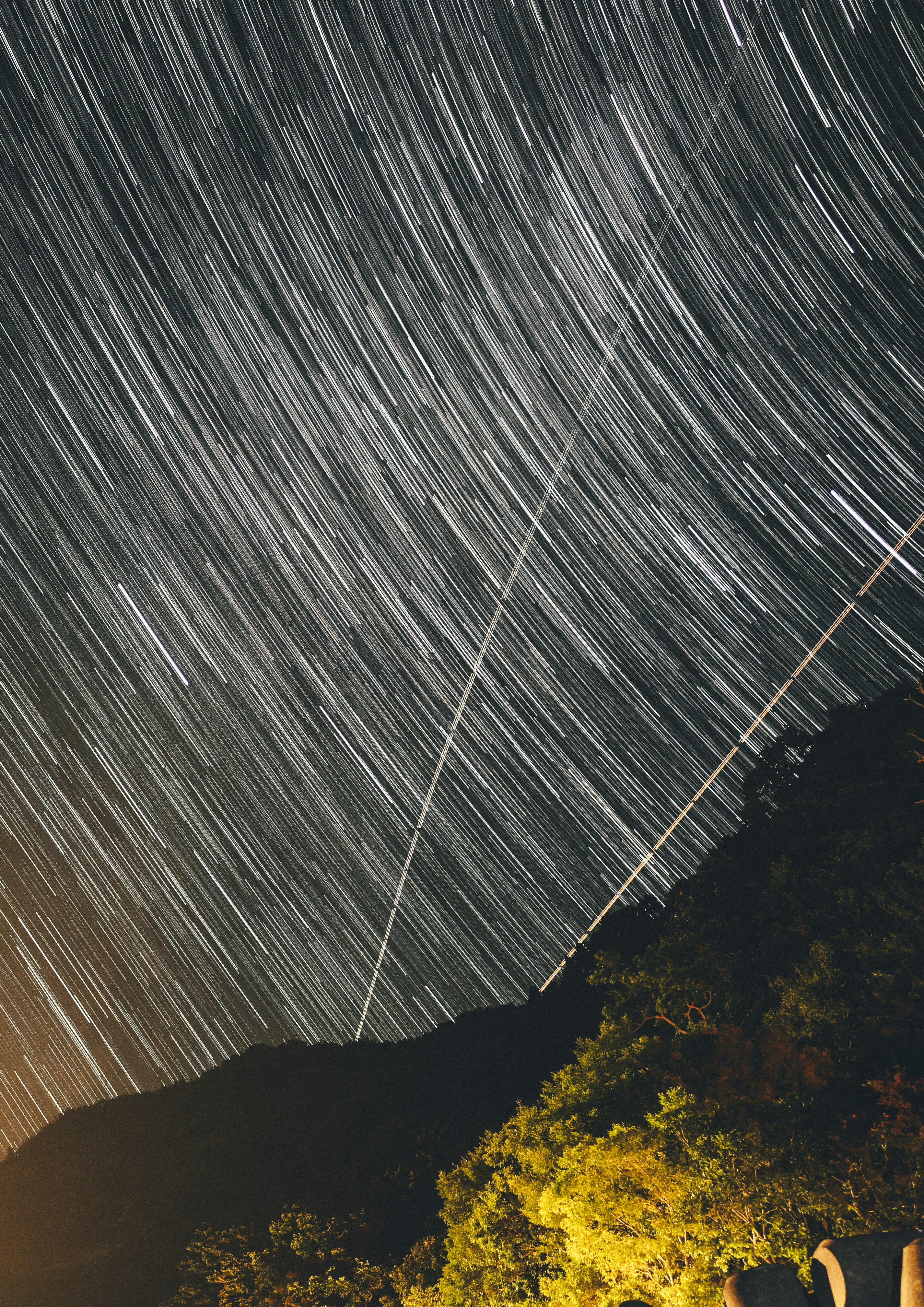 cielo notturno con scie di stelle sopra una cresta di montagna in silhouette