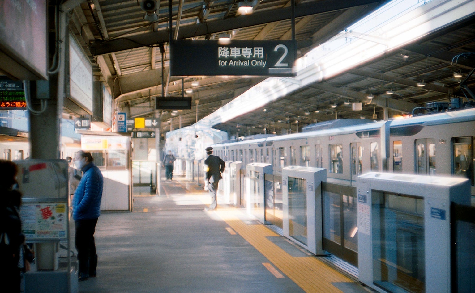 Photo of a train station platform with people and trains