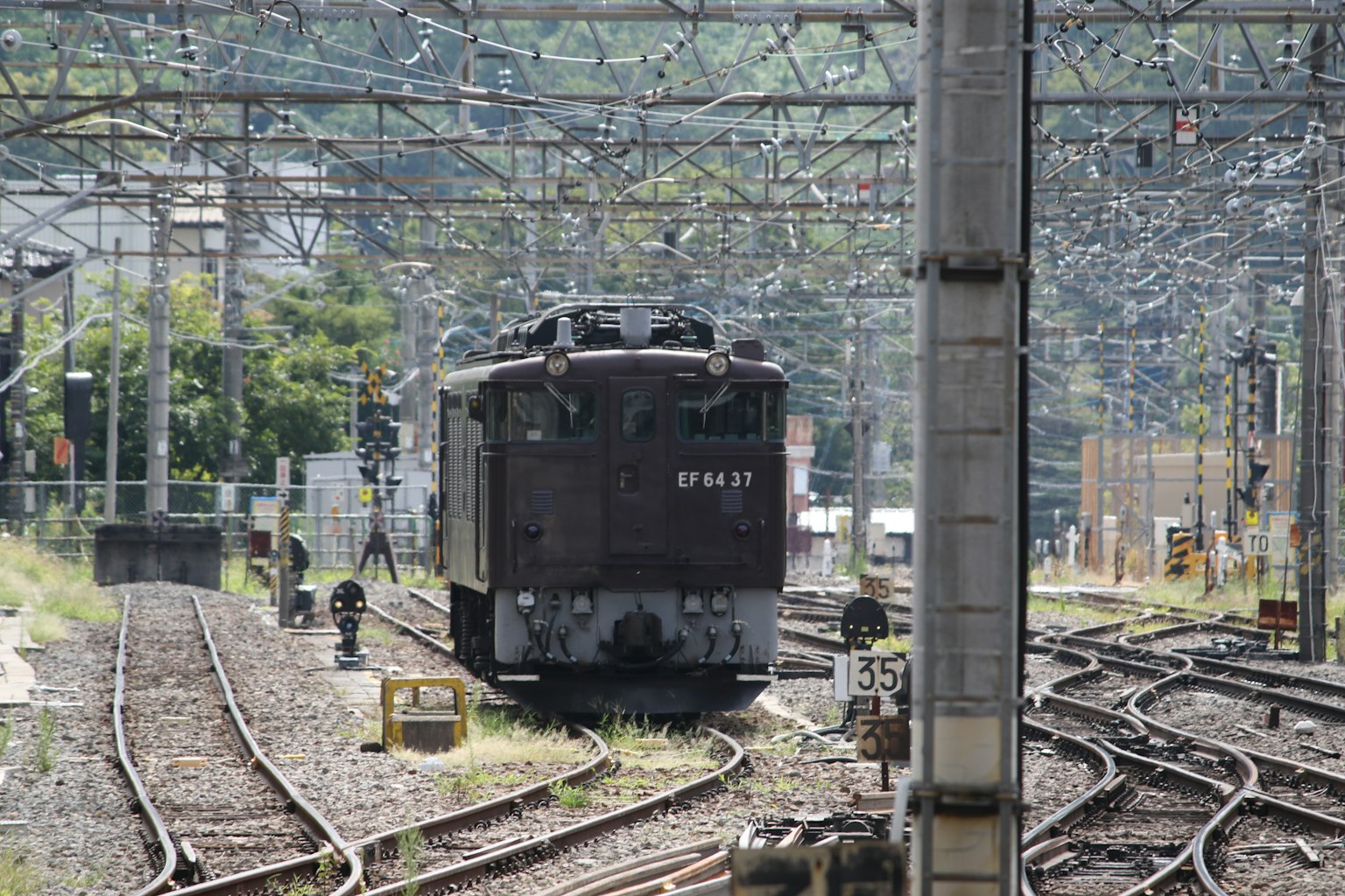 Sebuah kereta yang diparkir di rel dengan saluran udara terlihat di sekitarnya