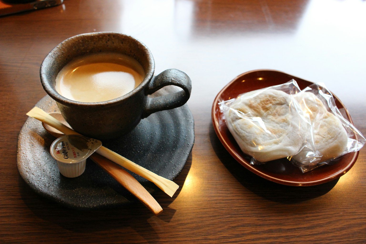 A cup of coffee and traditional Japanese sweets on a wooden table