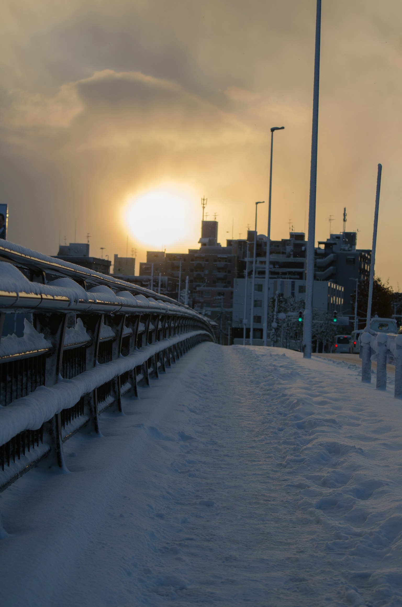 Camino cubierto de nieve con atardecer sobre el horizonte de la ciudad