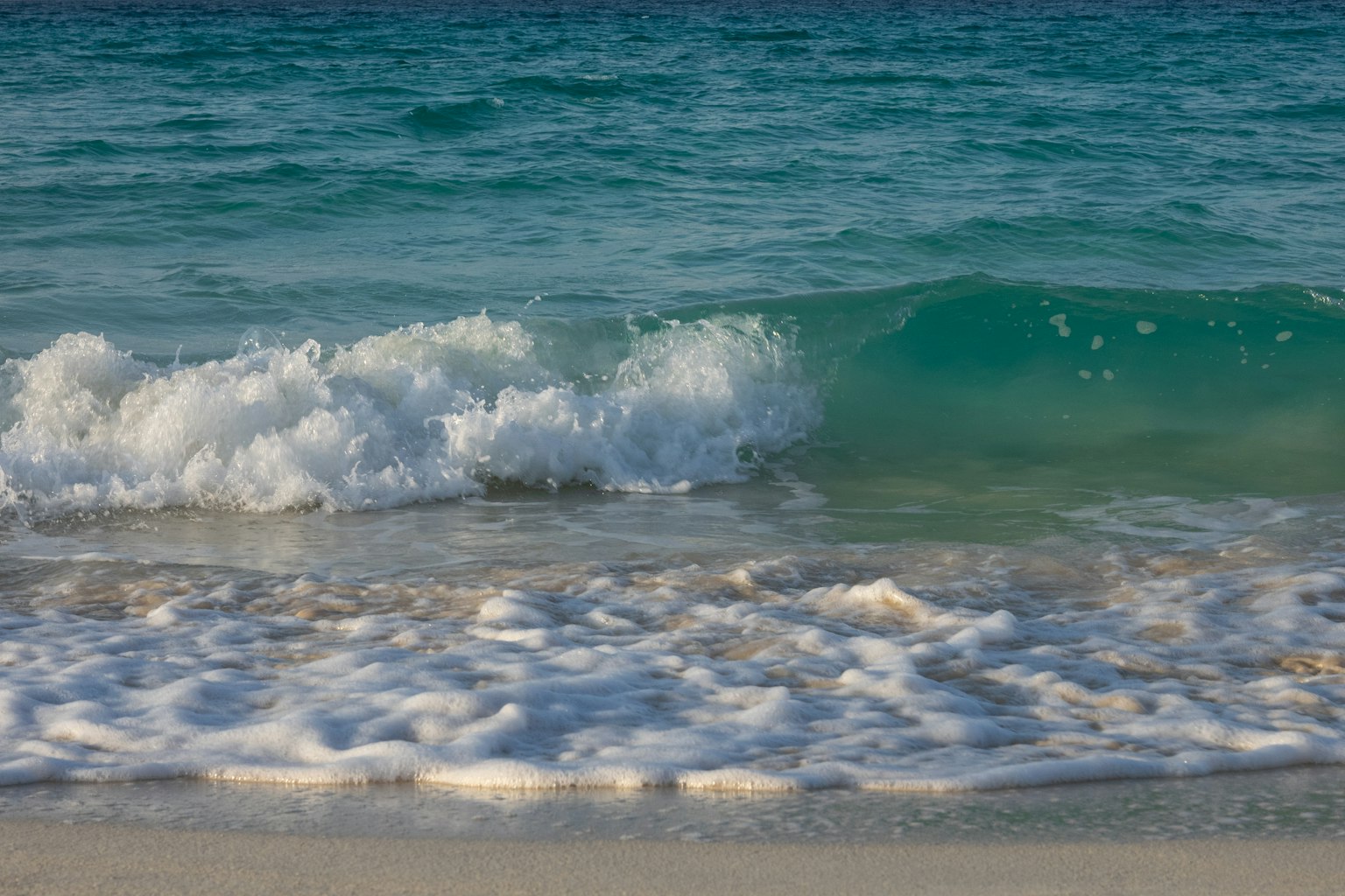 Eine ruhige Strandlandschaft mit blauen Ozeanwellen, die sanft an den Strand rollen