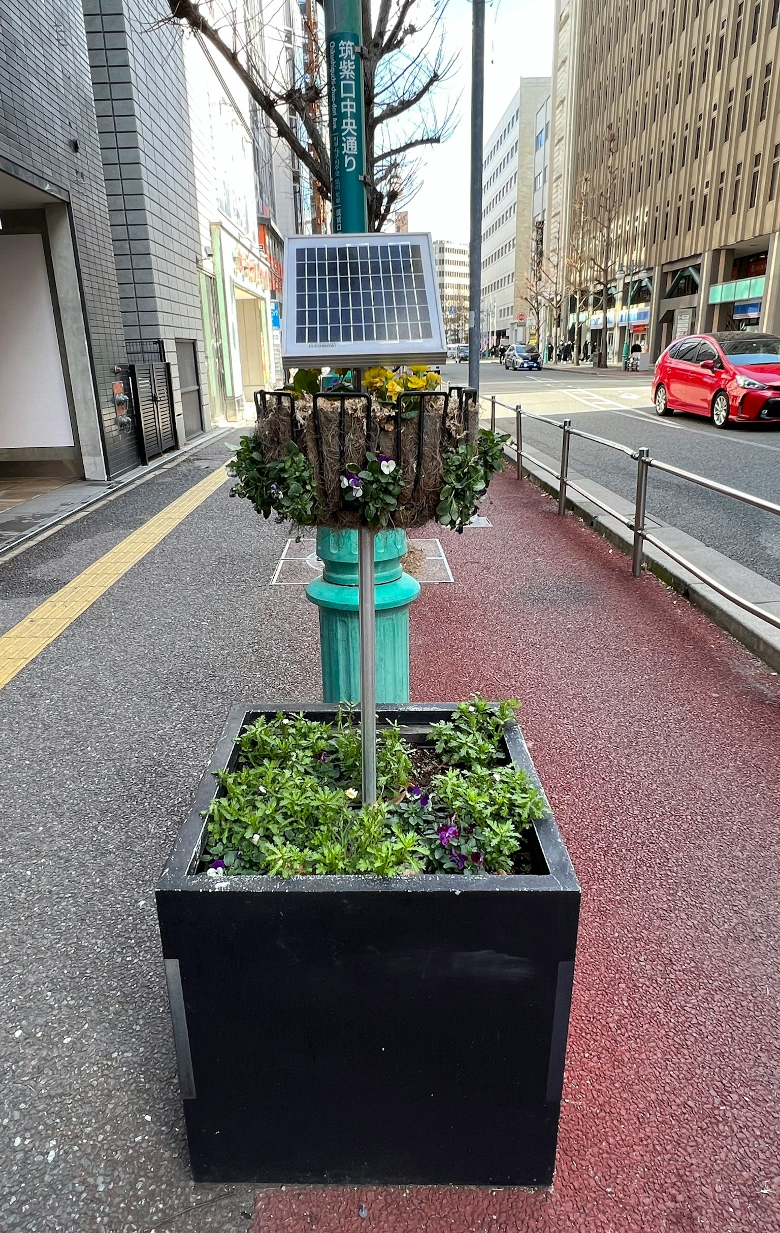 街道花箱，配有绿色植物和太阳能电池板