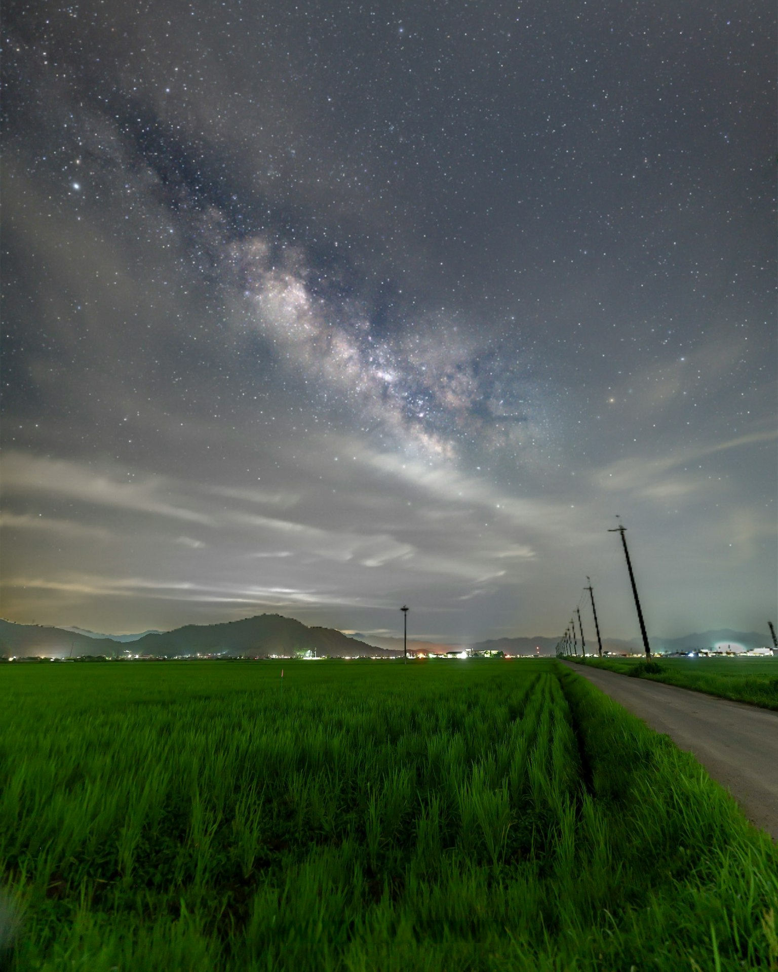 Ciel nocturne au-dessus d'un champ de riz avec la Voie lactée et des nuages