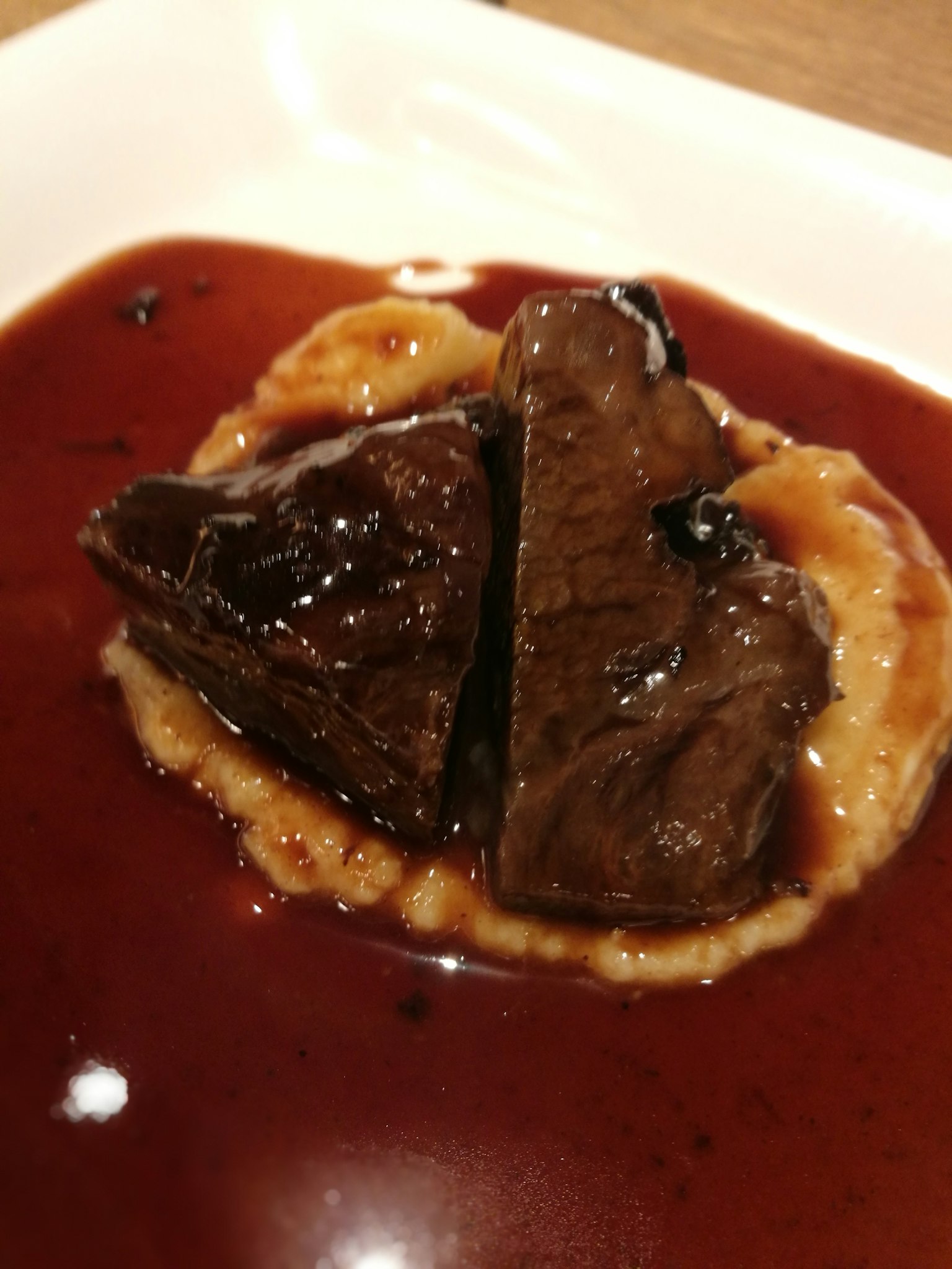 Morçeaux de viande tendre nappés de sauce au vin rouge servis sur une sauce crémeuse