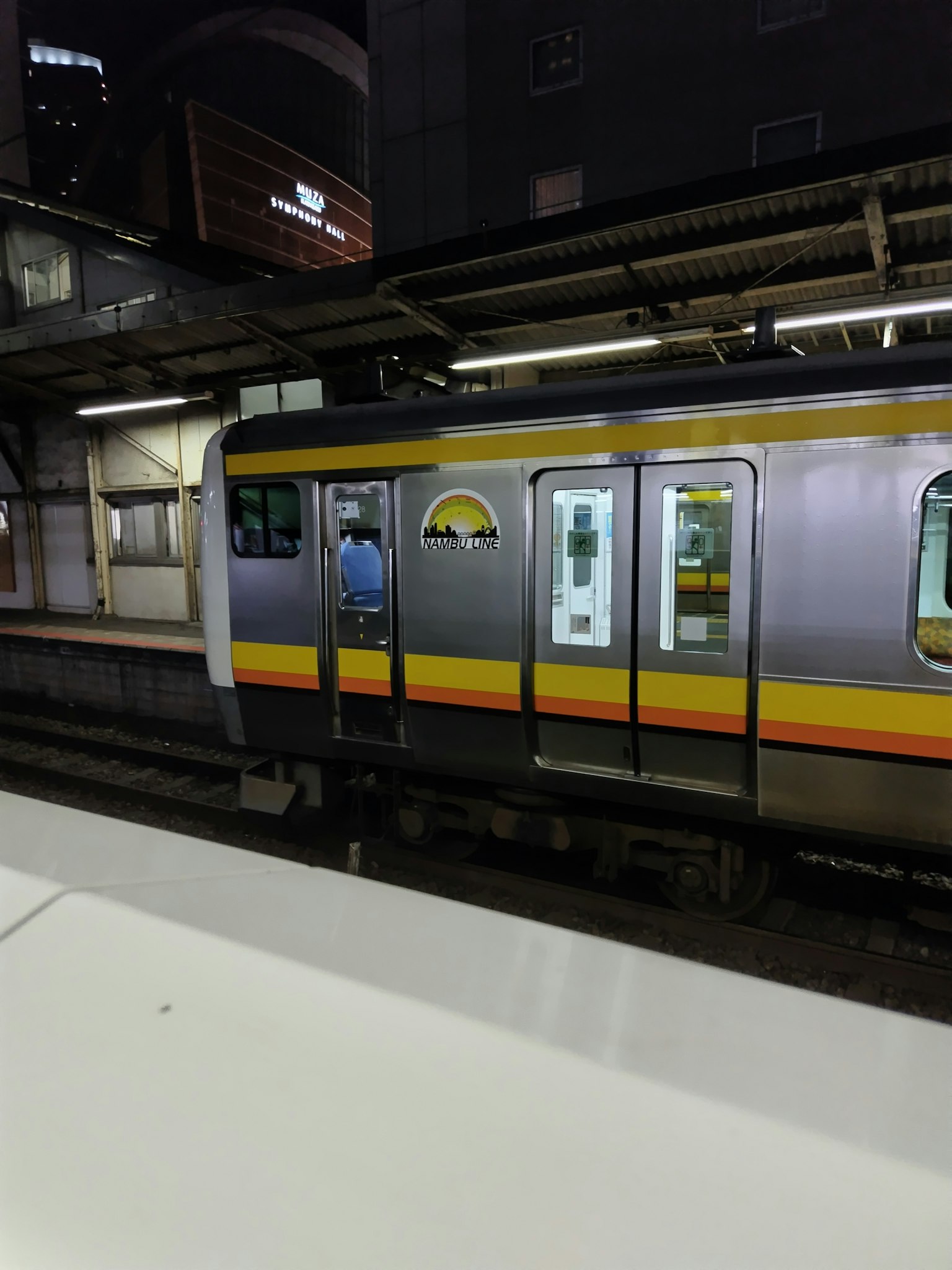 Sisi kereta yang berhenti di stasiun pada malam hari
